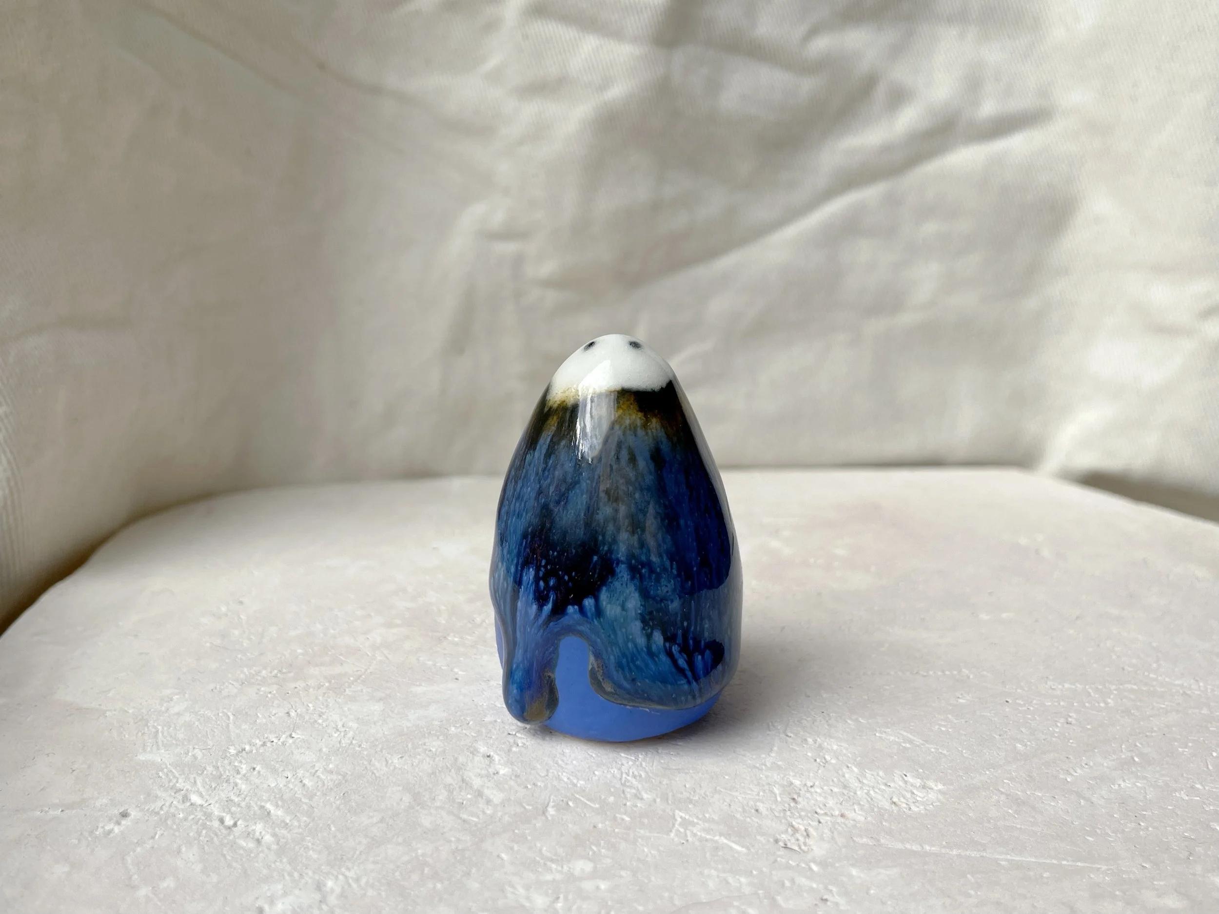 Blue, yellow, black handmade figurative ceramic sculpture with glossy runny floating glaze