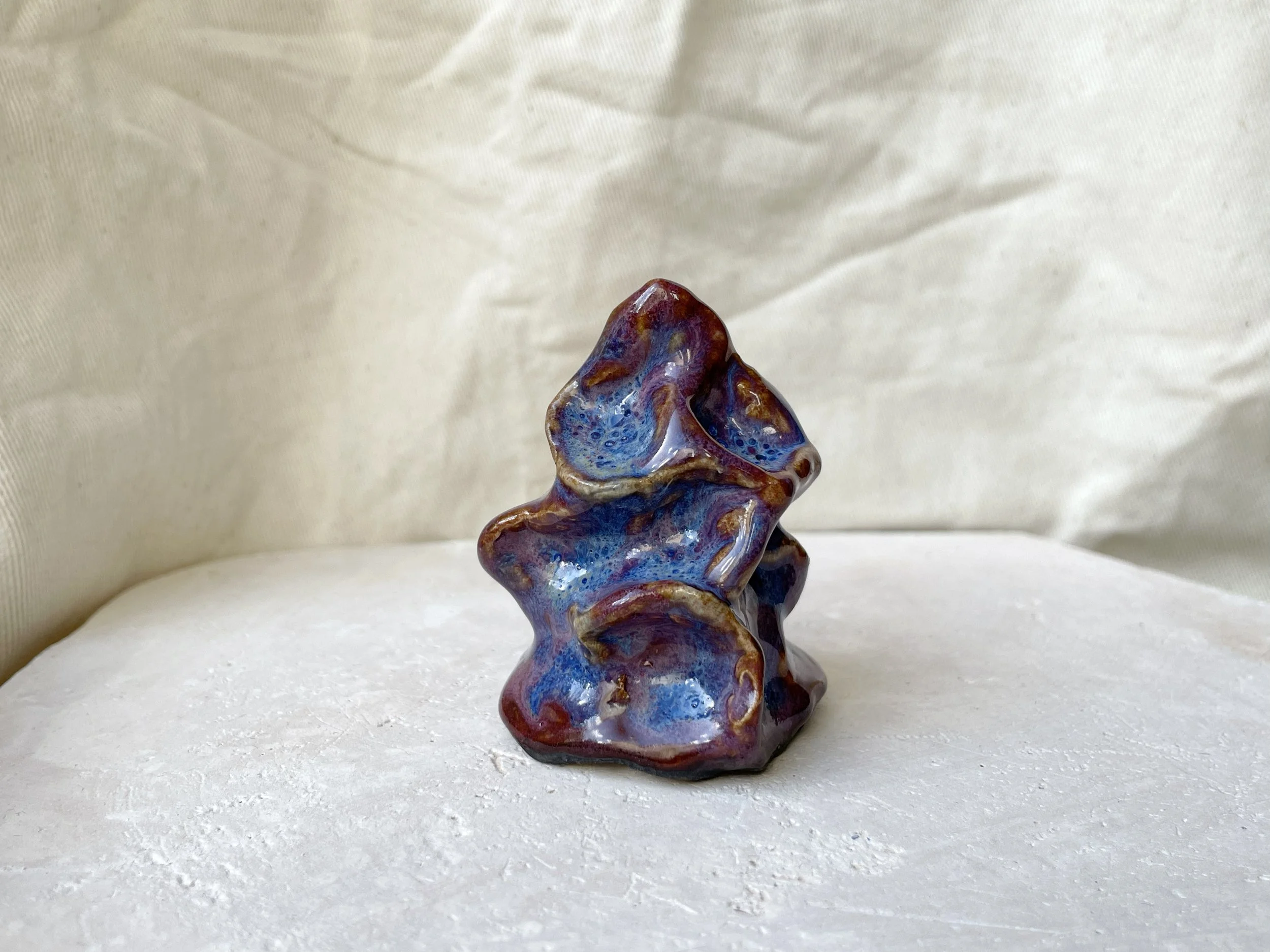 Blue, purple and red wavy handmade figurative ceramic sculpture with underglaze and runny glaze