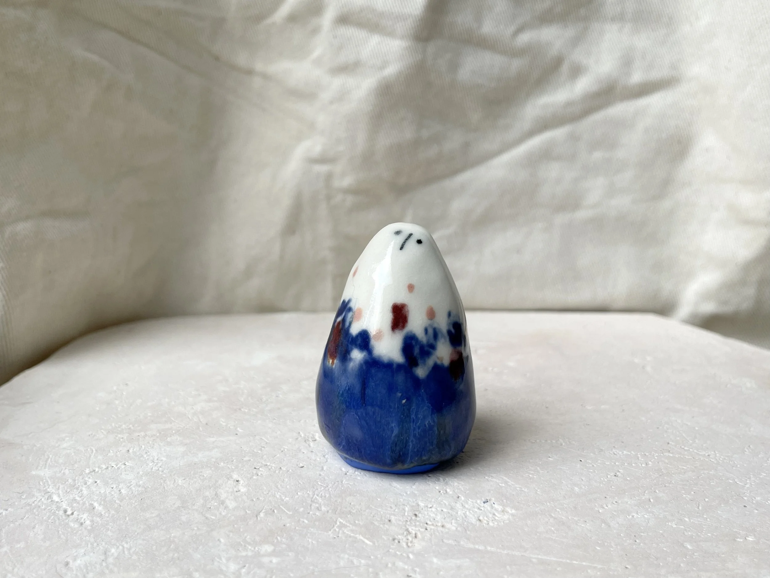 Blue, white, red and pink handmade figurative ceramic sculpture with glossy glaze and underglaze