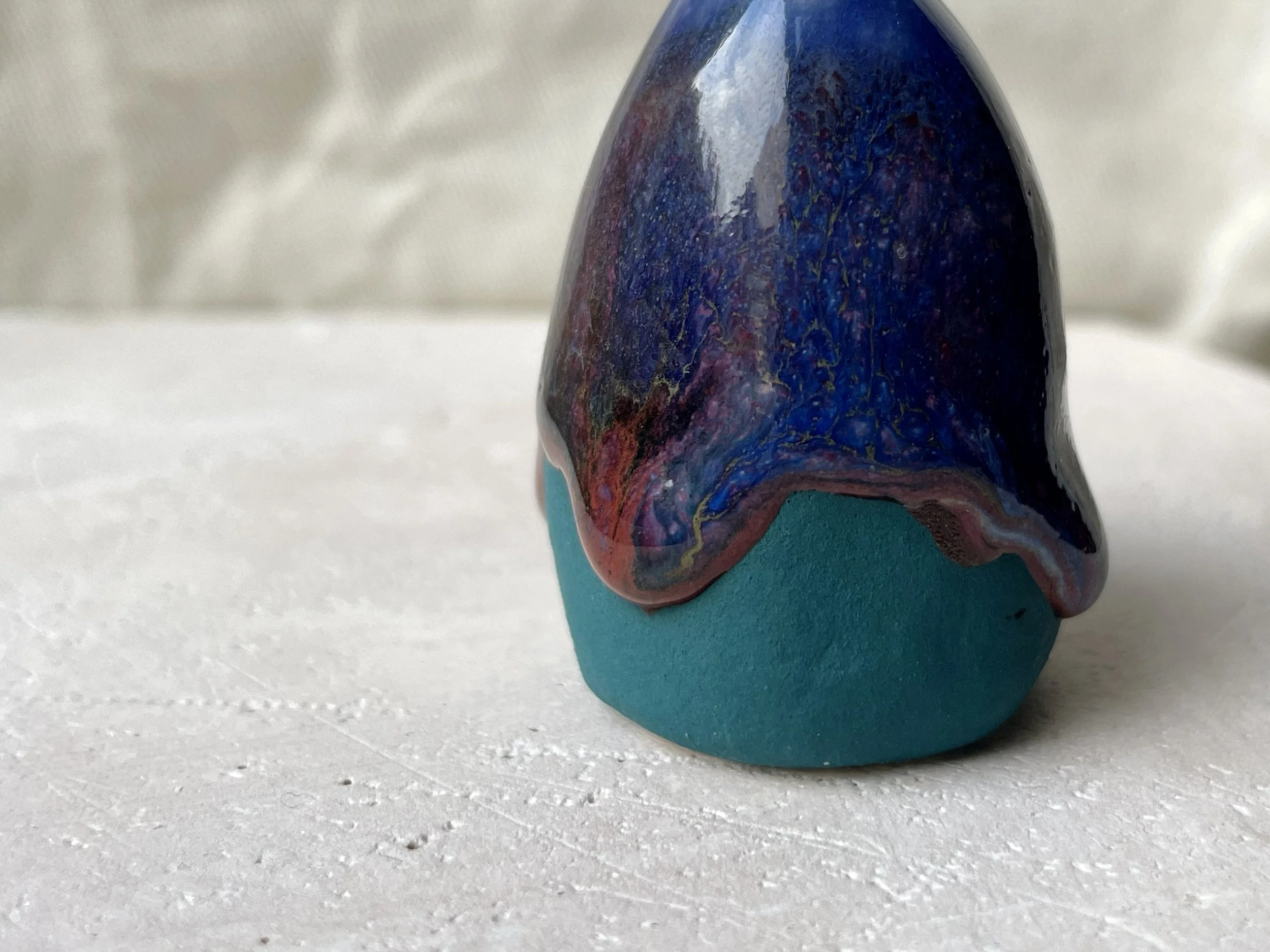 Blue, green and red handmade figurative ceramic sculpture with underglaze and drippy runny glaze