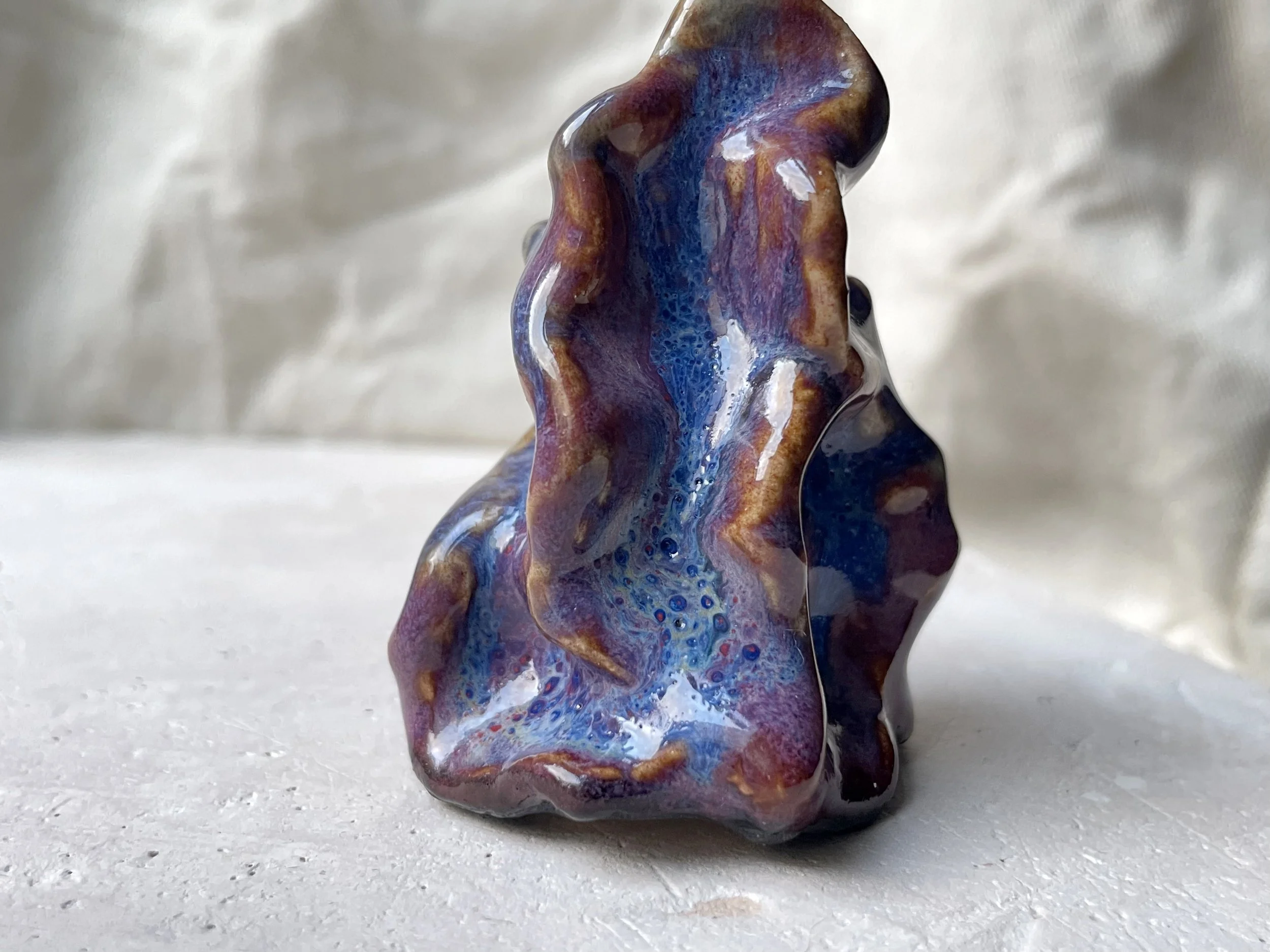 Wavy purple, red and blue handmade figurative ceramic sculpture with glossy floating glaze and underglaze