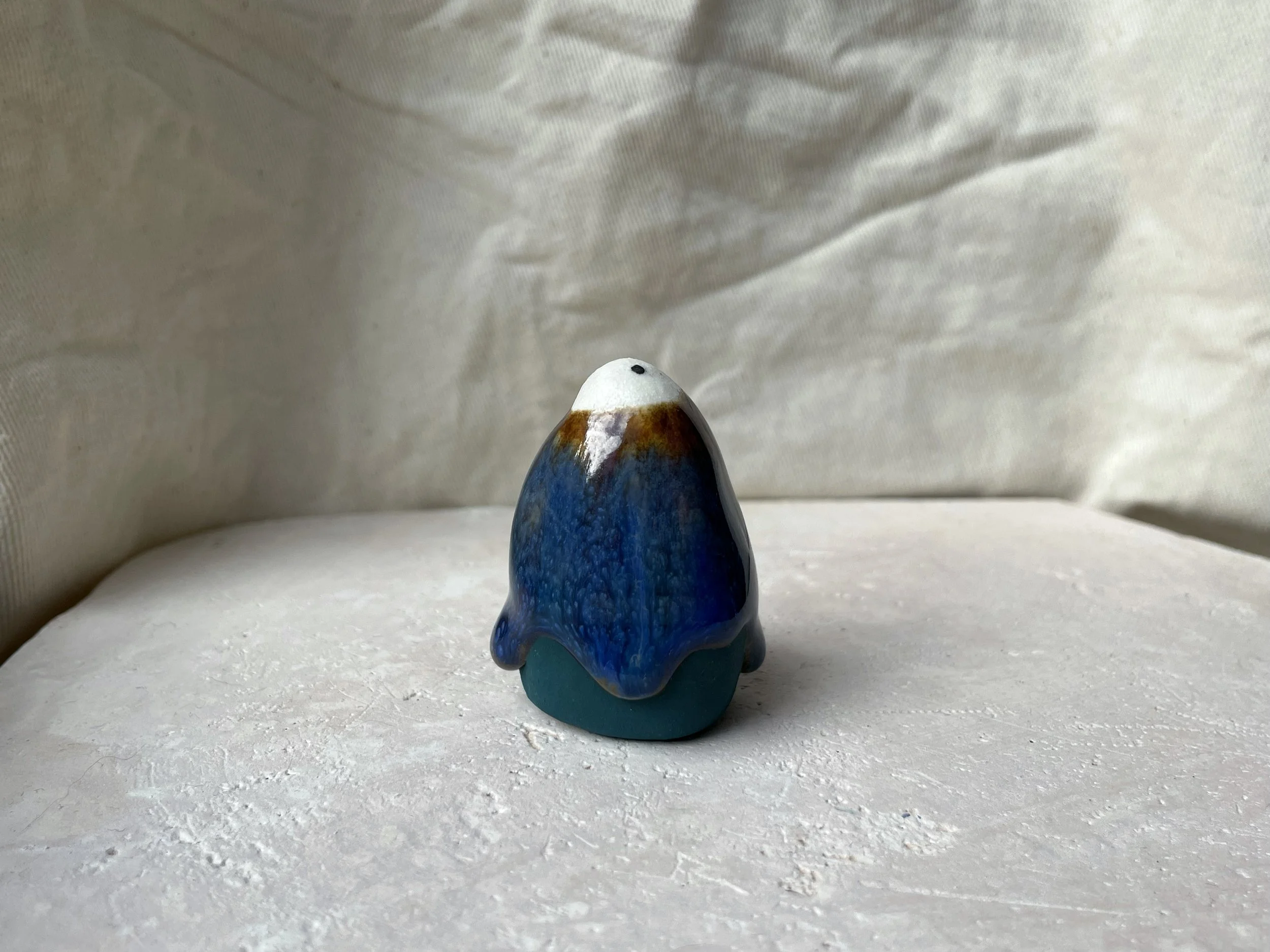 brown, blue and green handmade figurative ceramic sculpture with glossy drippy floating glaze