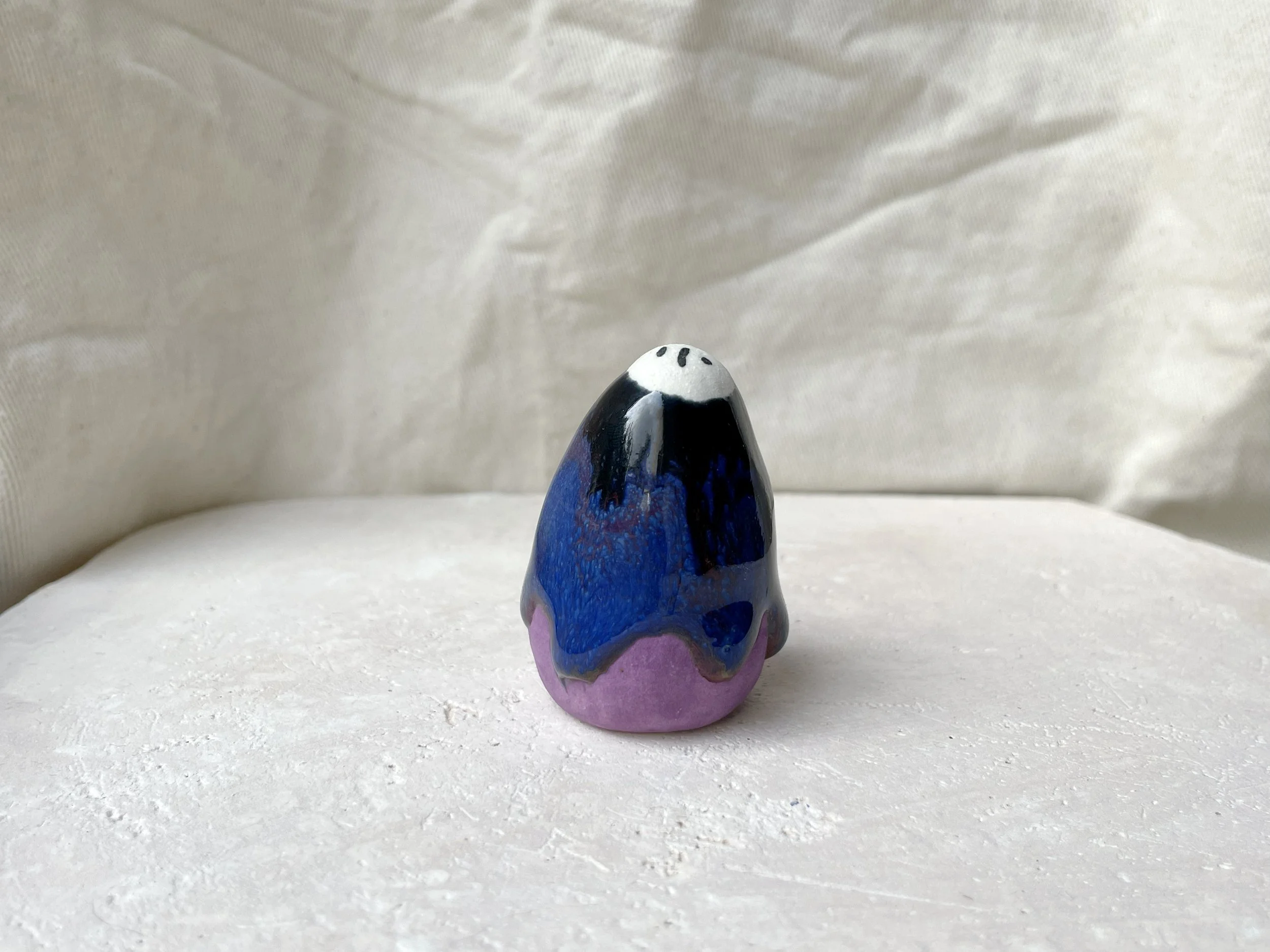 Purple, blue and black handmade figurative ceramic sculpture with glossy drippy glaze