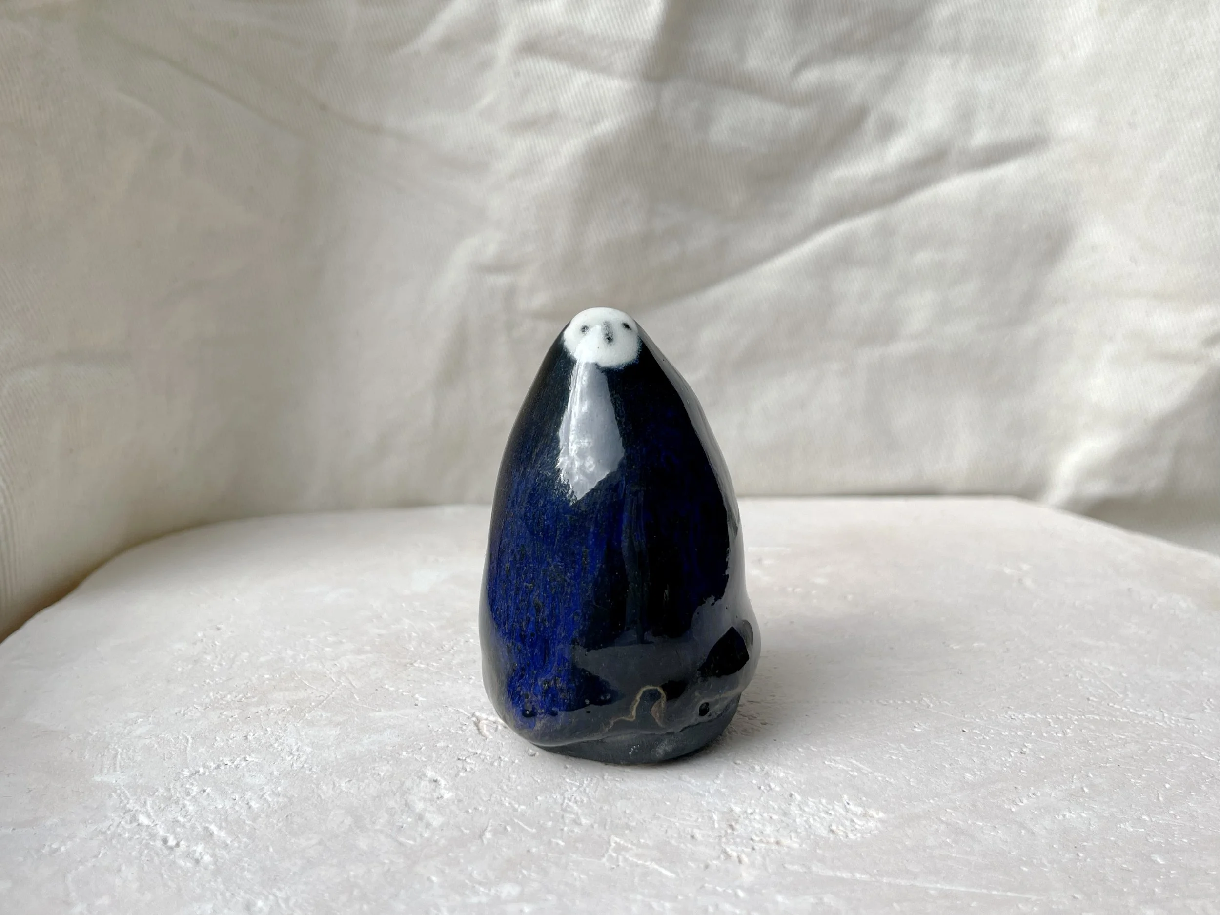 black and blue and gold handmade figurative ceramic sculpture with glossy floating glaze