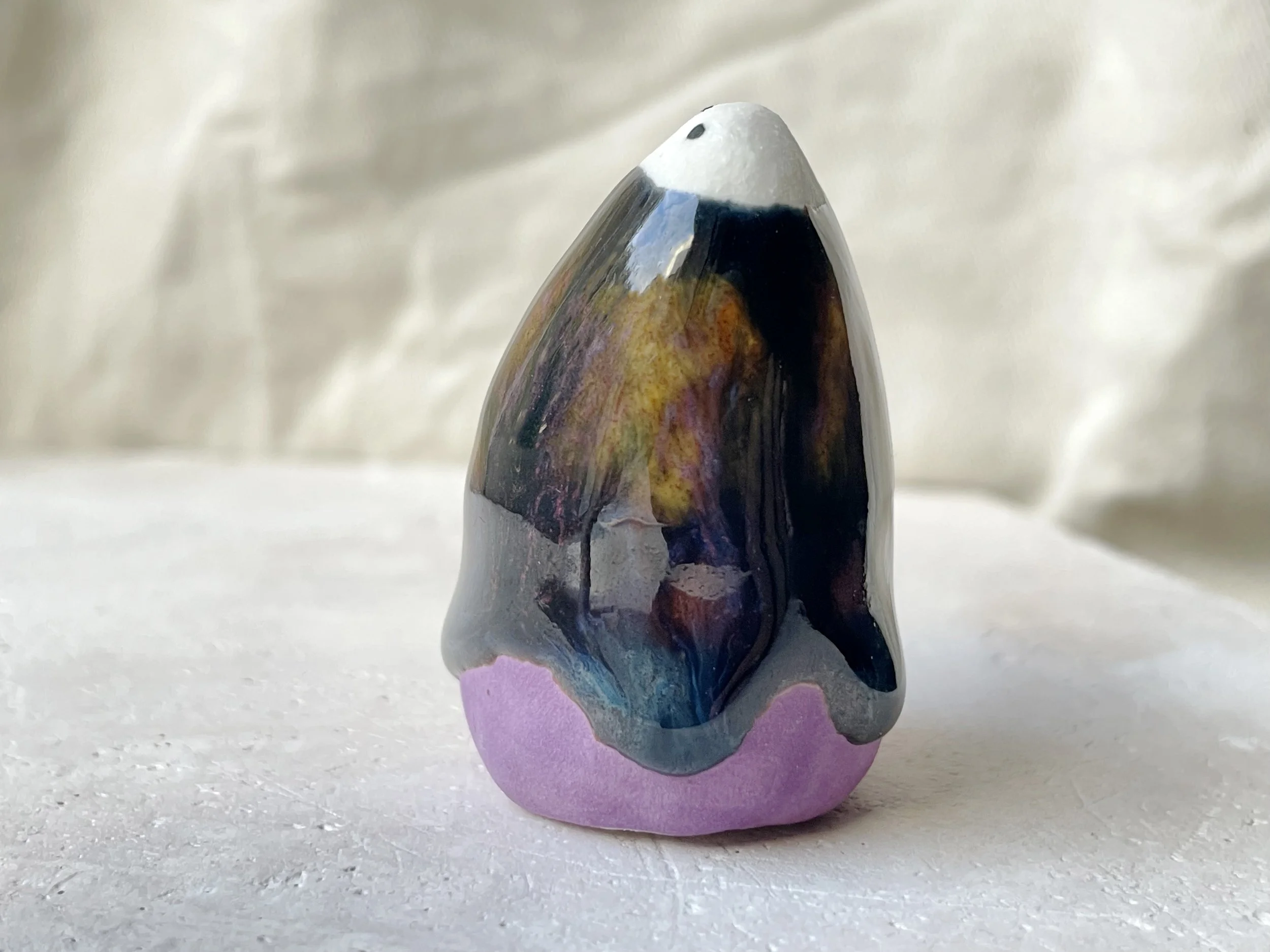 Purple, black, orange, blue handmade figurative ceramic sculpture with underglaze and drippy runny glaze