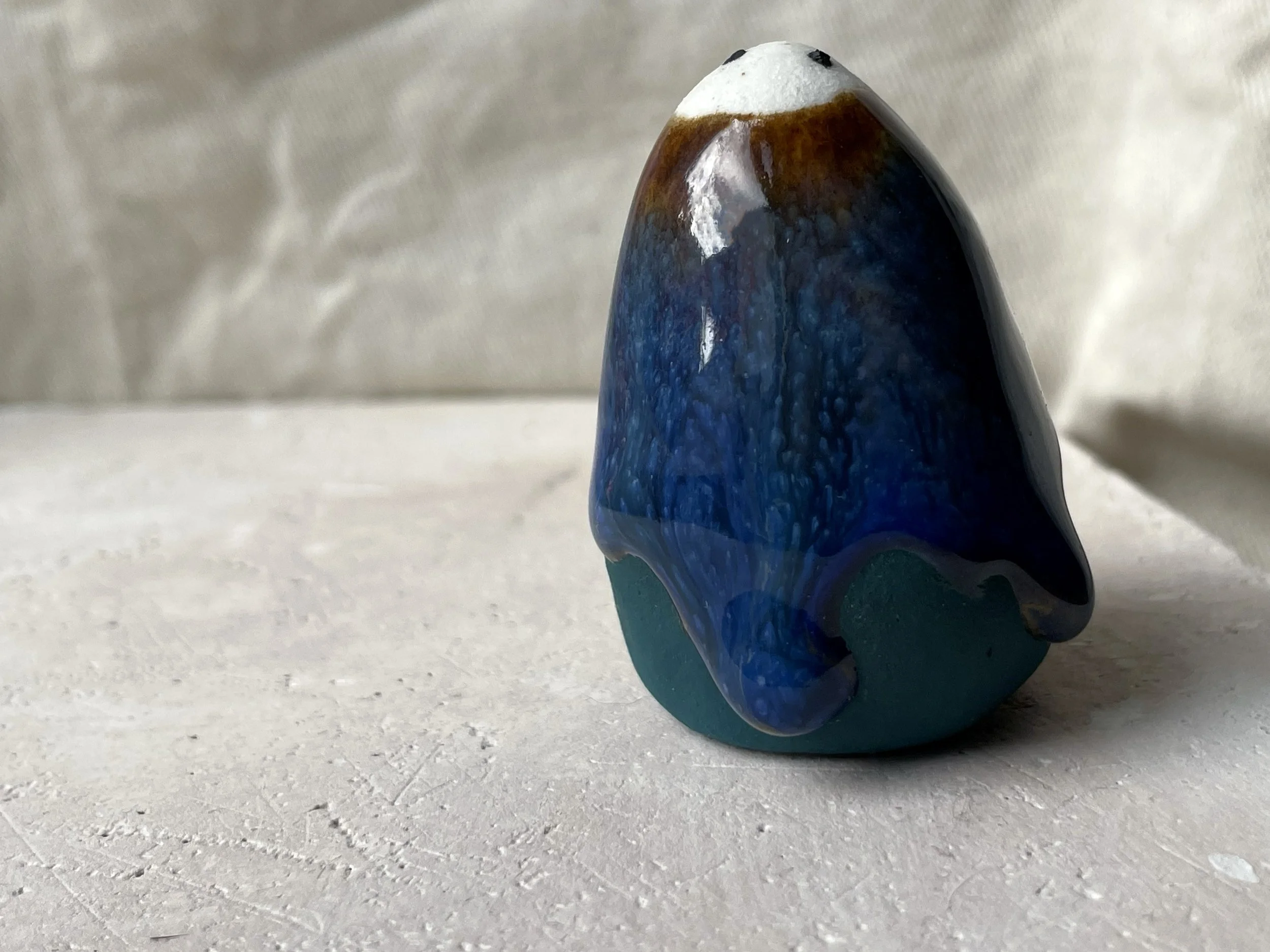 brown, blue and green handmade figurative ceramic sculpture with glossy drippy floating glaze