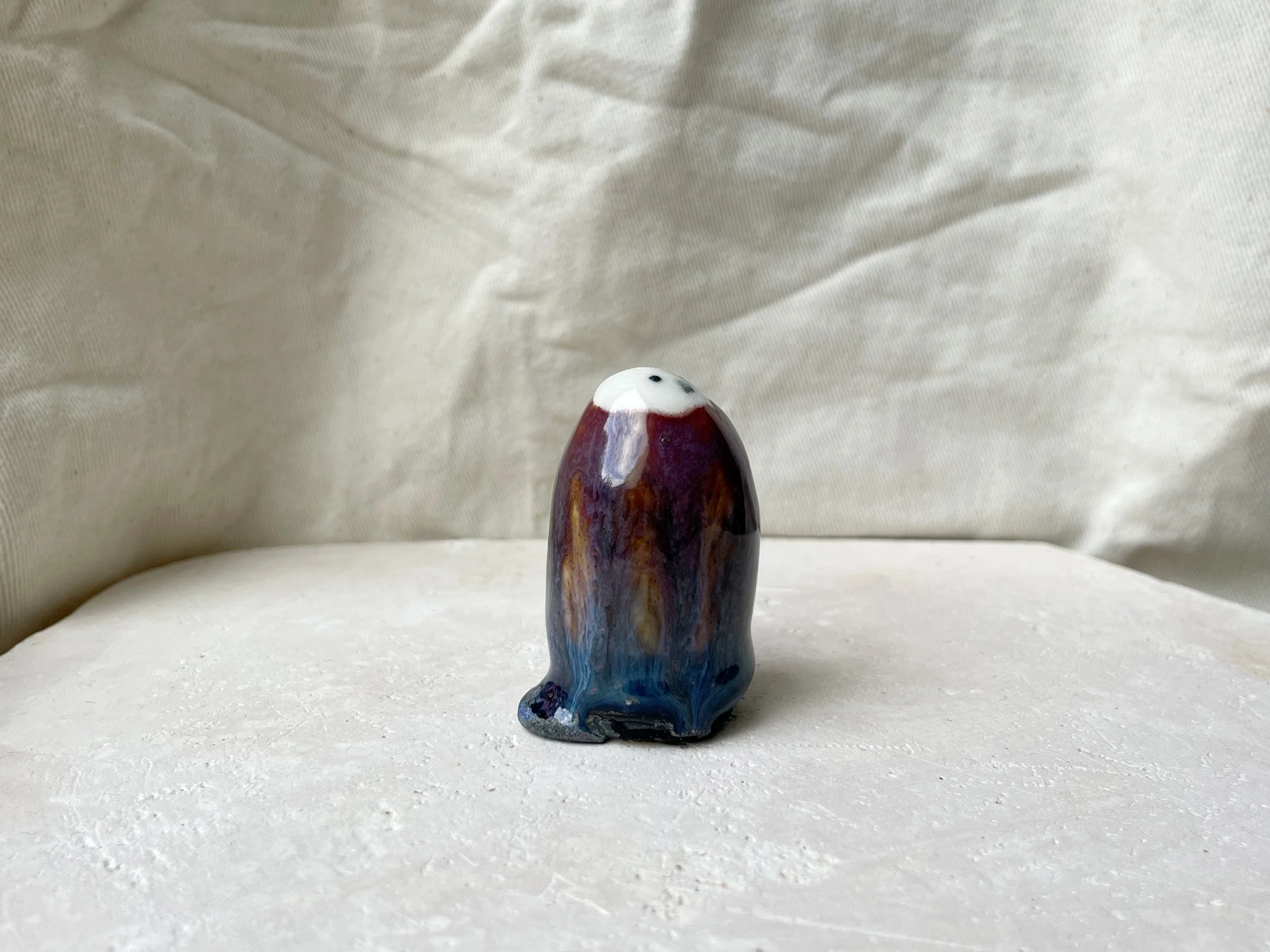 Purple, orange, blue and black handmade figurative ceramic sculpture with underglaze and drippy float glaze