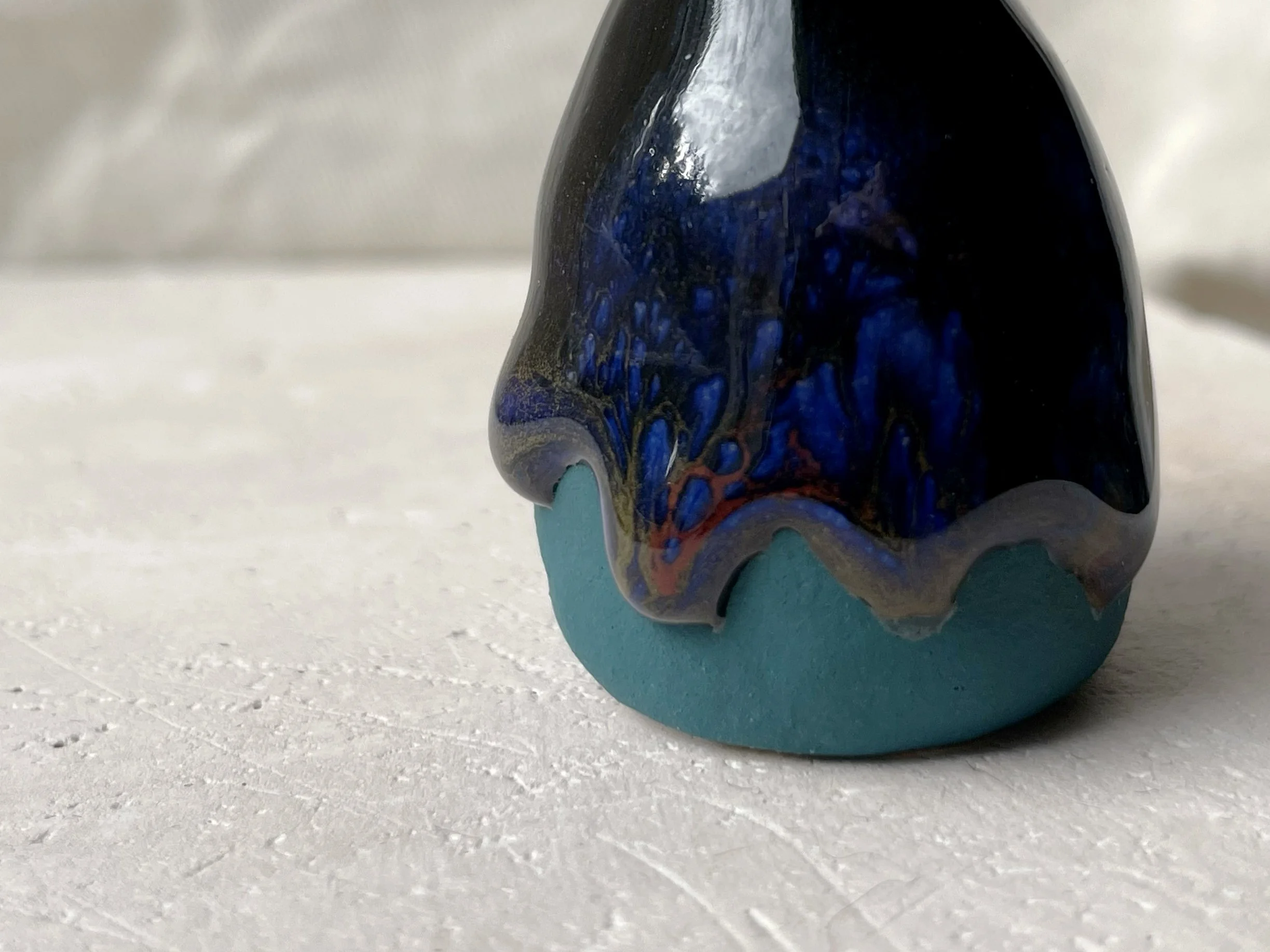 Black, blue and green handmade figurative ceramic sculpture with glossy drippy floating glaze