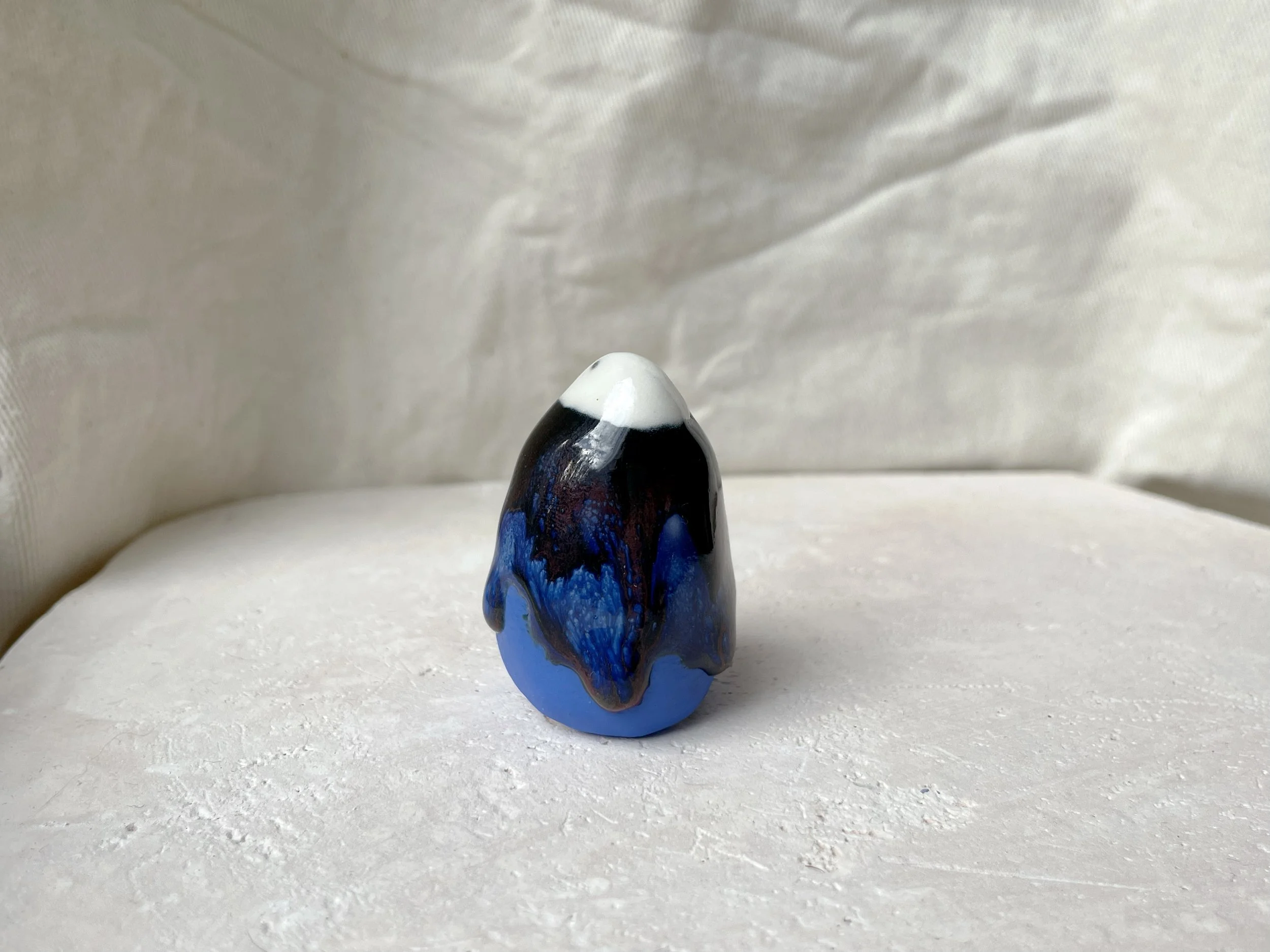 blue, red and black handmade figurative ceramic sculpture with glossy runny floating glaze