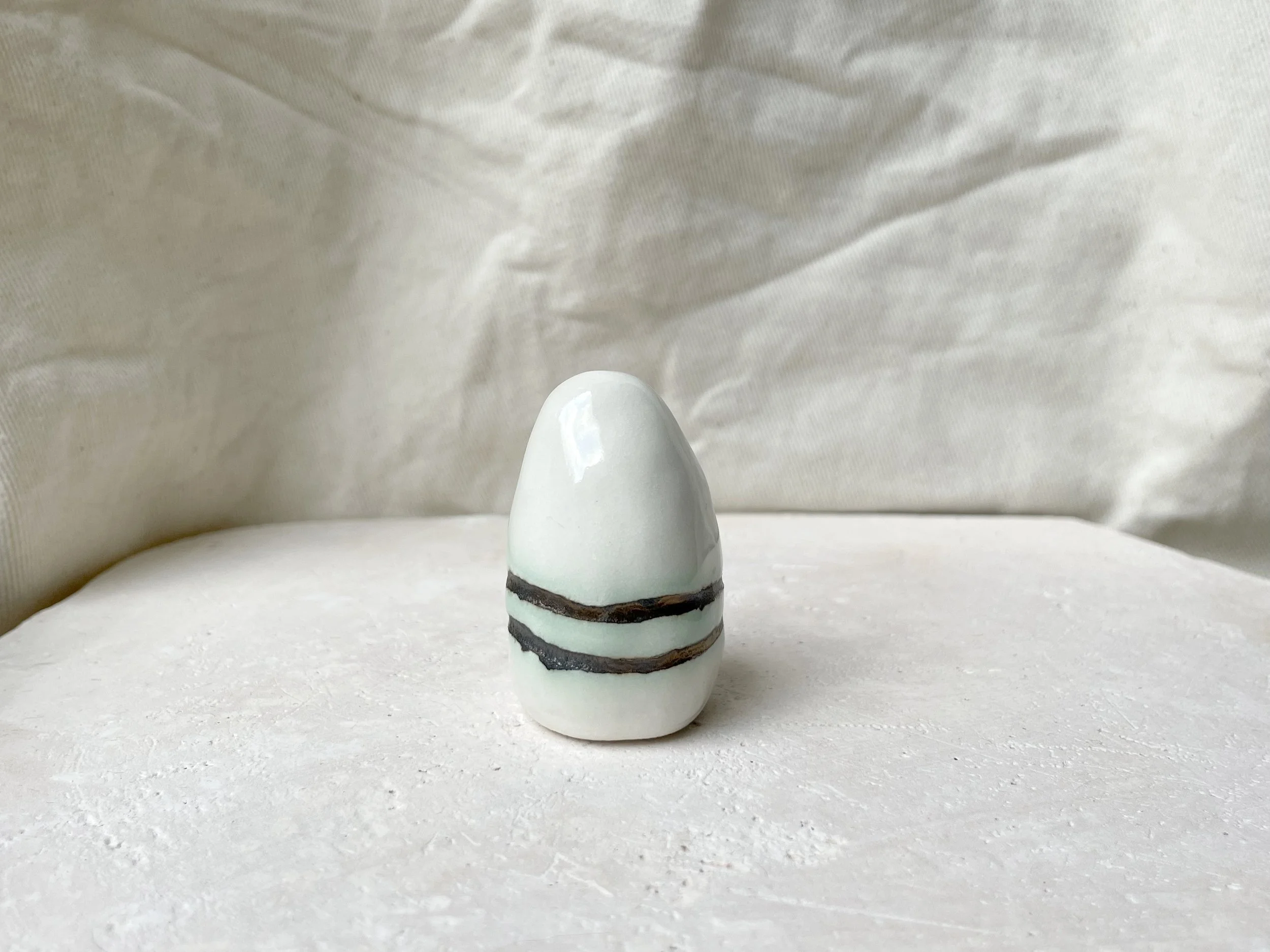 White and gold glossy handmade figurative ceramic sculpture with metallic glaze and hint of green