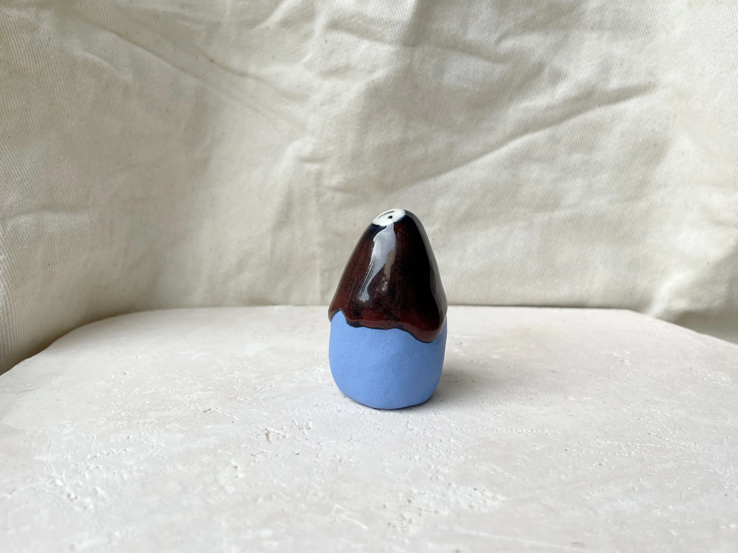 Blue, red and black handmade figurative ceramic sculpture with glossy drippy glaze