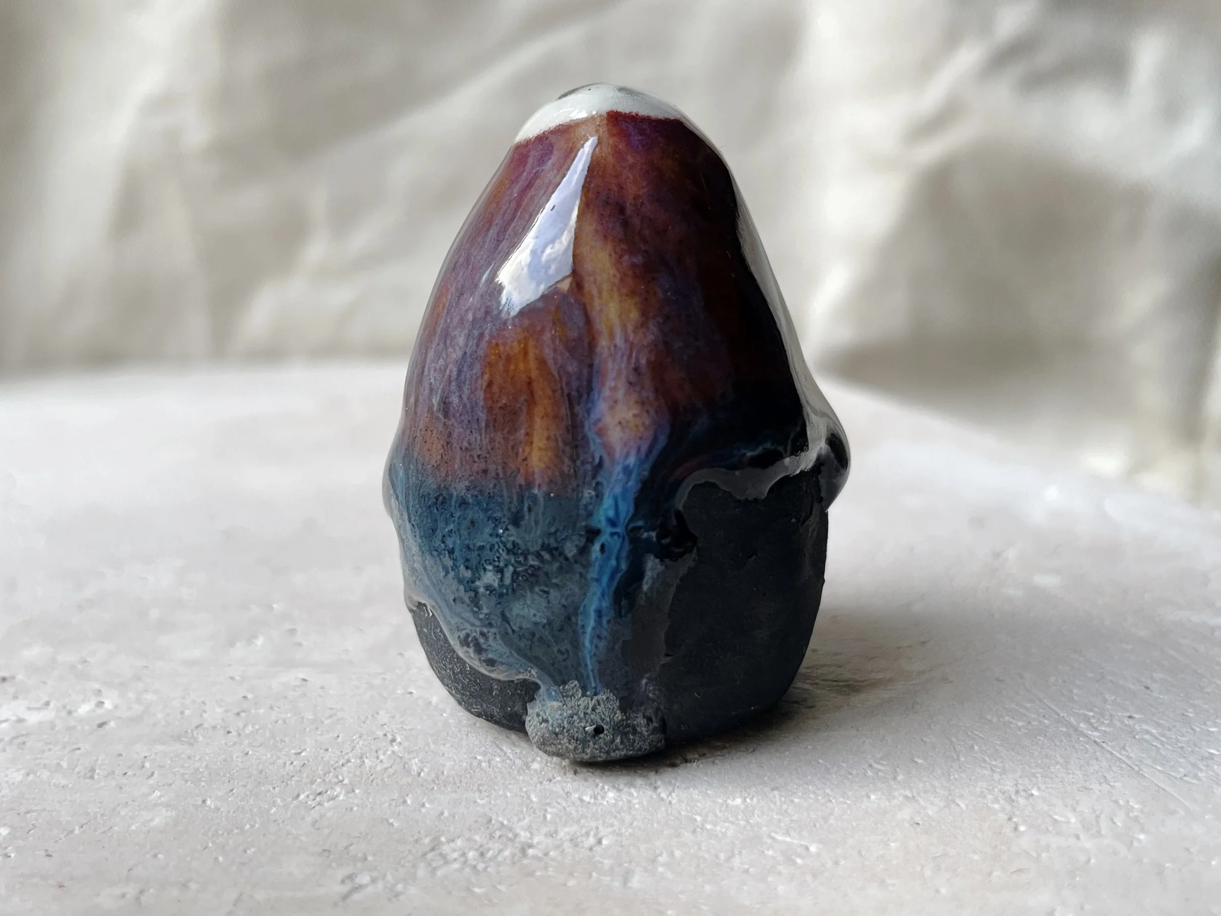 Blue, orange, purple and black handmade figurative ceramic sculpture with underglaze and drippy float glaze