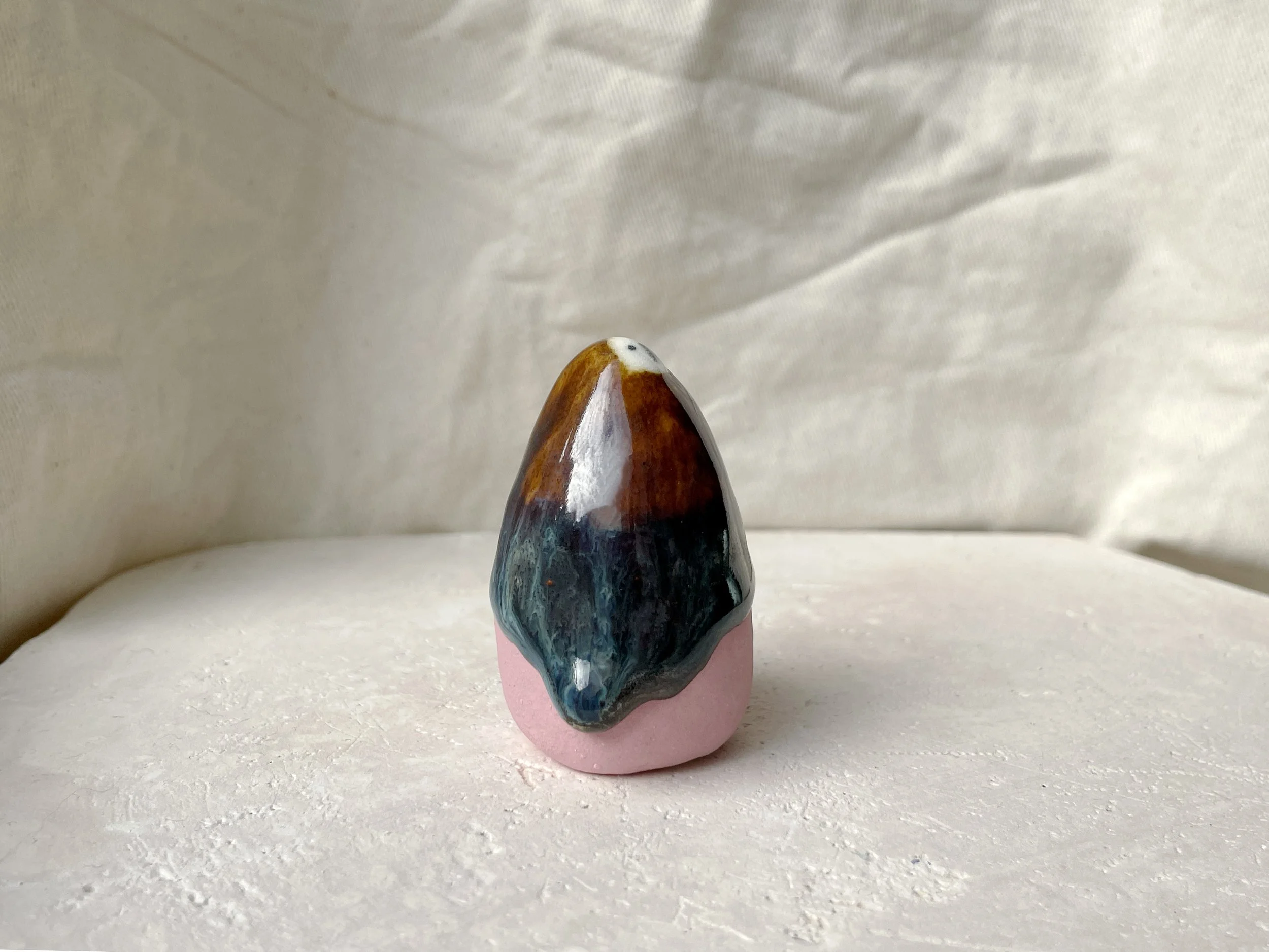 Brown, blue and pink handmade figurative ceramic sculpture with glossy drippy floating glaze