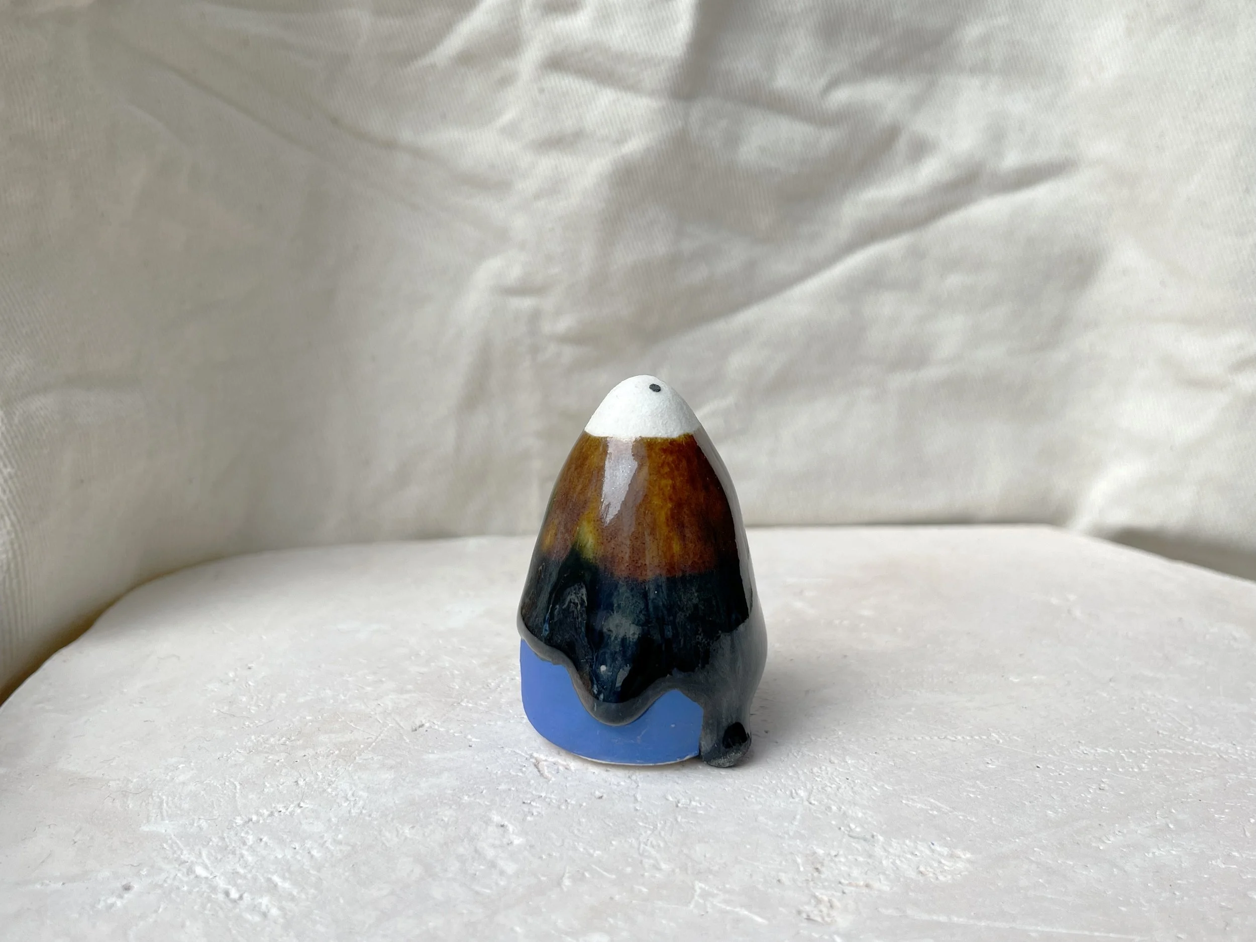 Blue, brown and black handmade figurative ceramic sculpture with runny drippy glaze