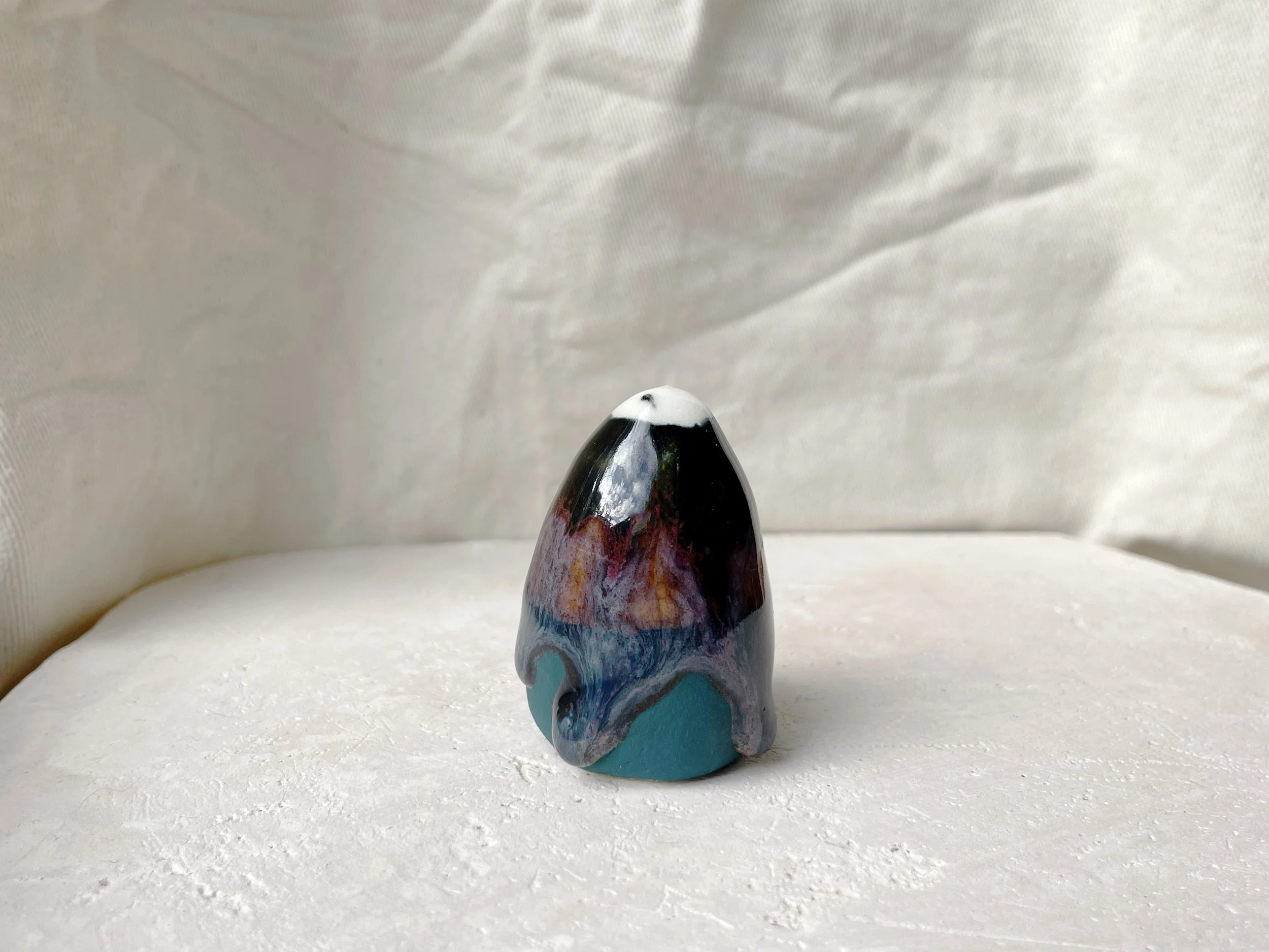 Black, purple, green and blue handmade figurative ceramic sculpture with glossy drippy floating glaze