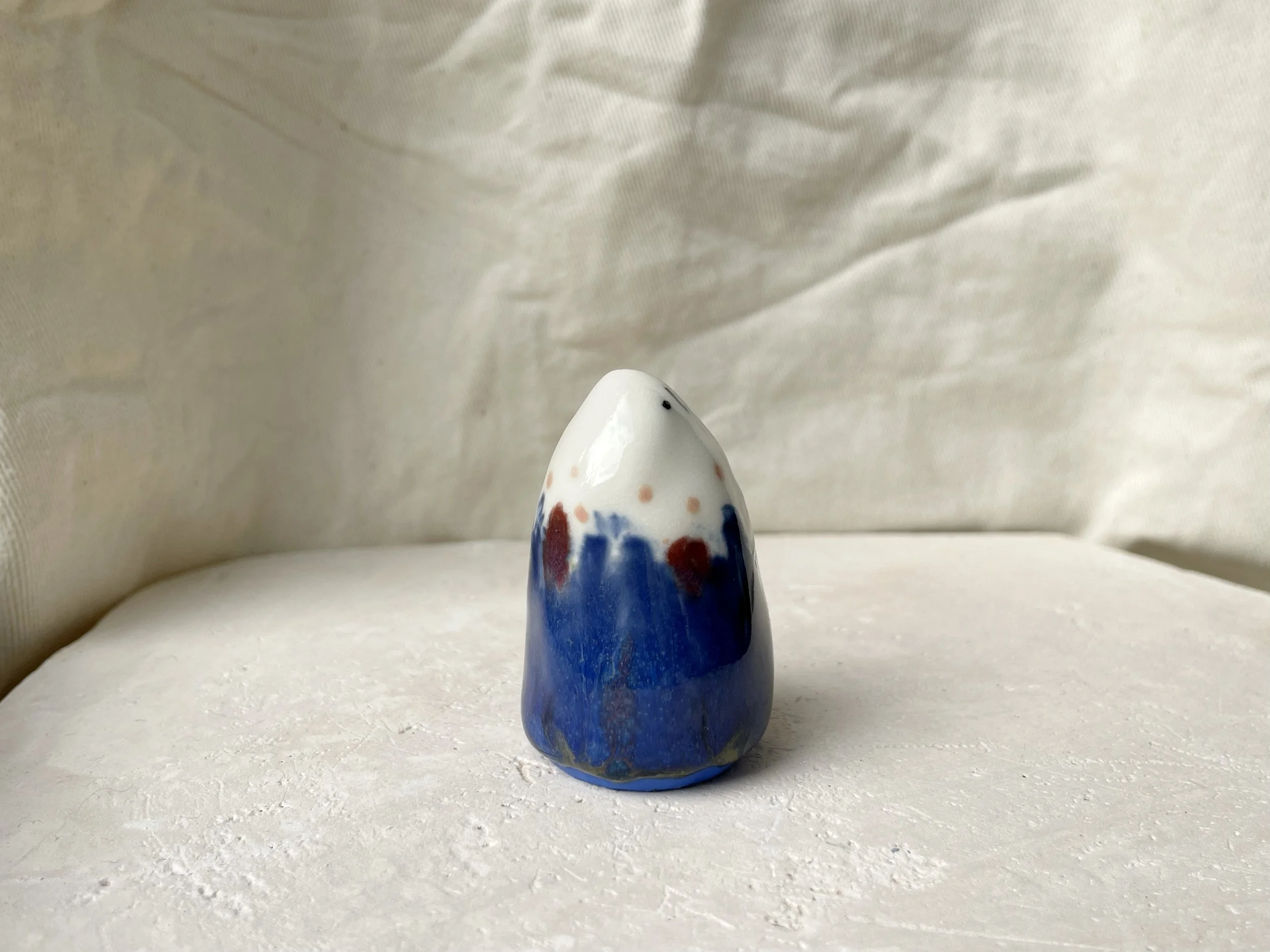 blue, white, red and pink handmade figurative ceramic sculpture with underglaze and glaze