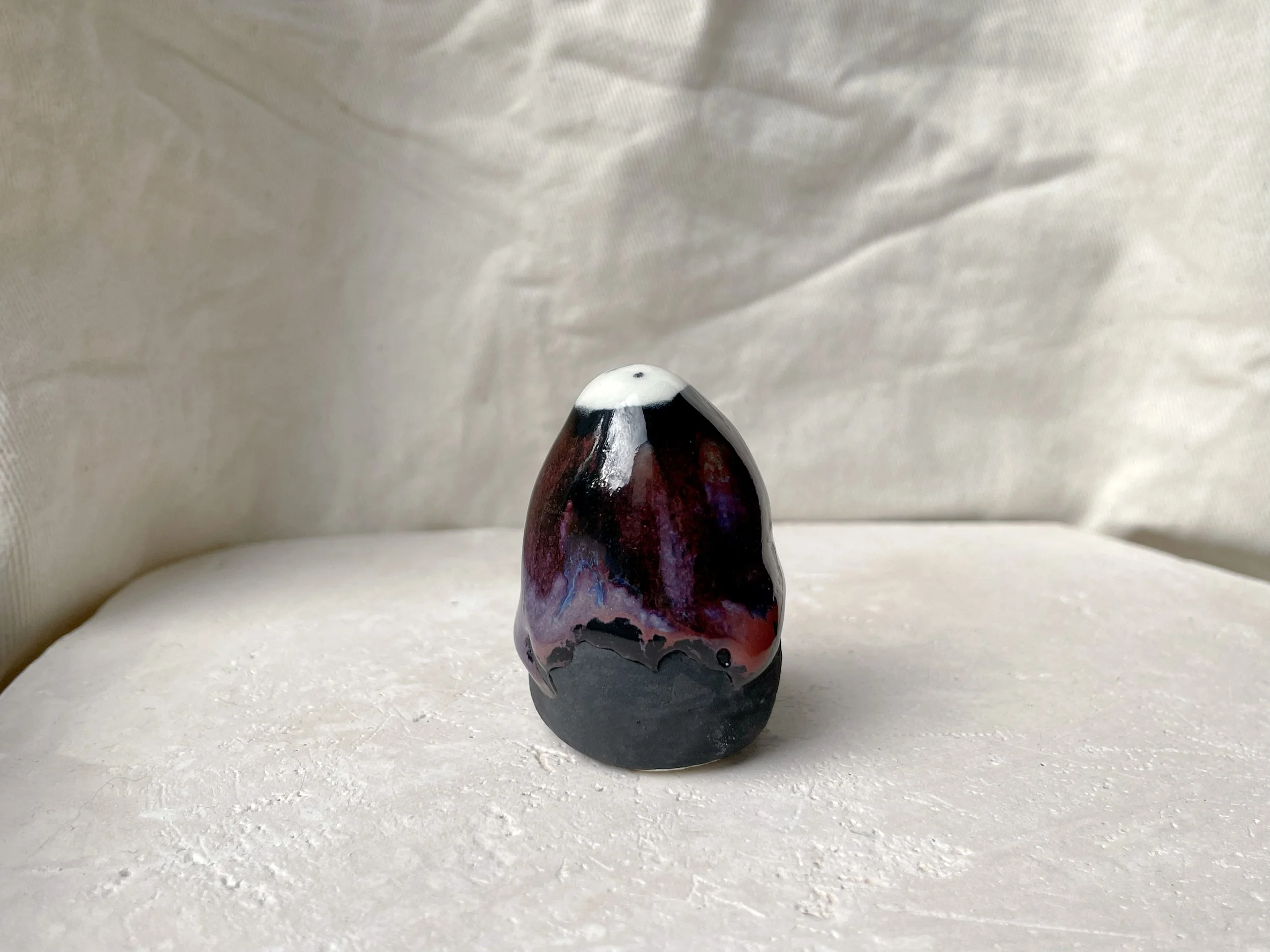 purple, black and red handmade figurative ceramic sculpture with glossy drippy floating glaze
