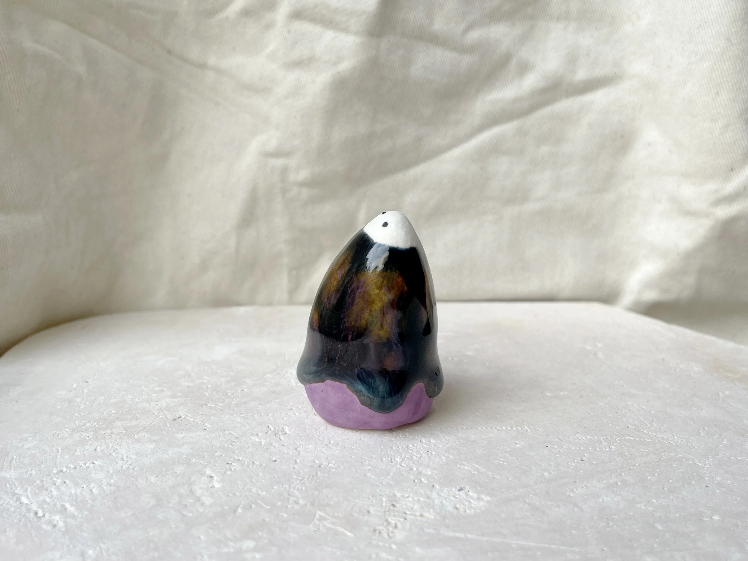 Purple, black, orange, blue handmade figurative ceramic sculpture with underglaze and drippy runny glaze