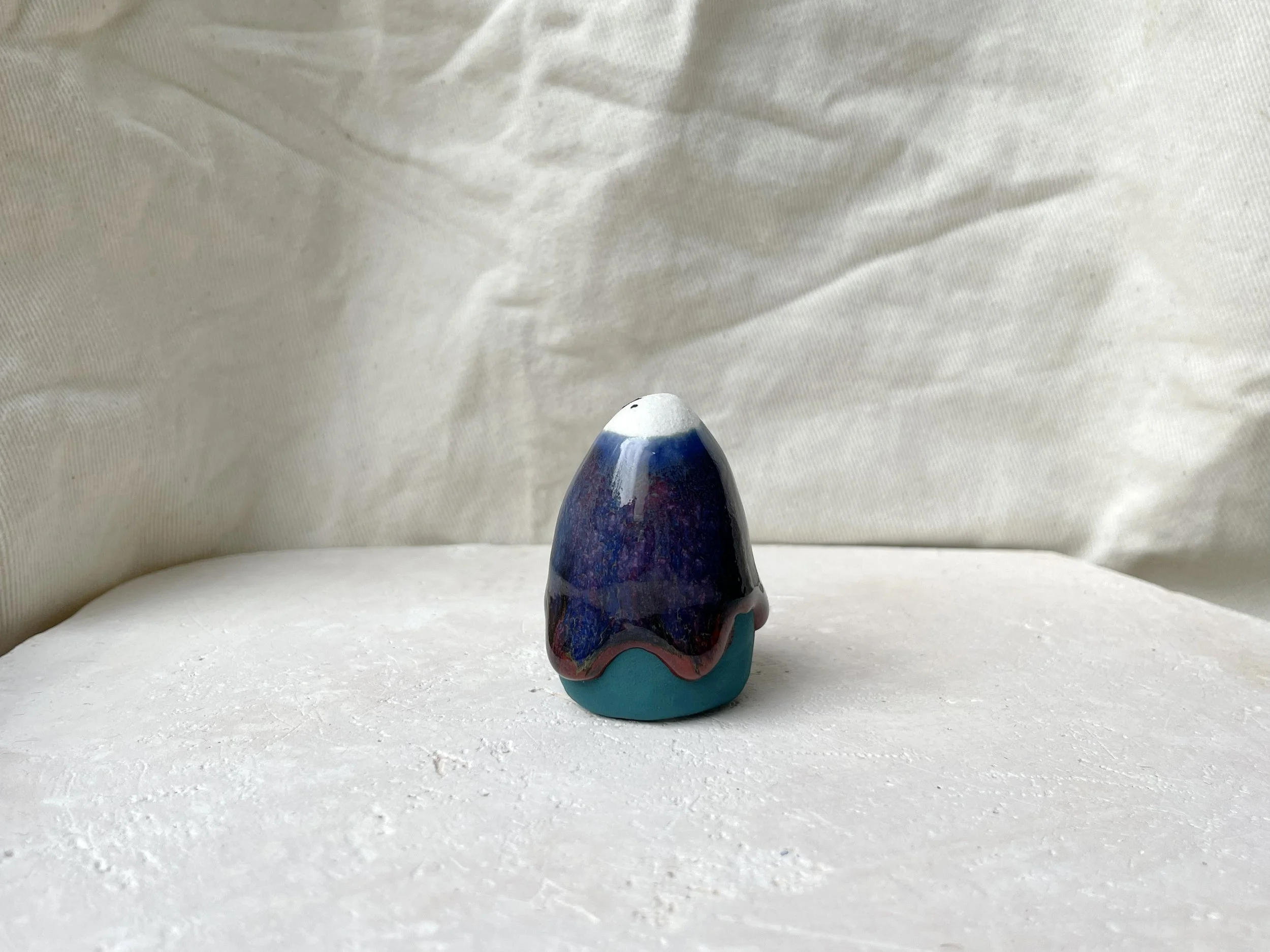 Blue, green and red handmade figurative ceramic sculpture with underglaze and drippy runny glaze