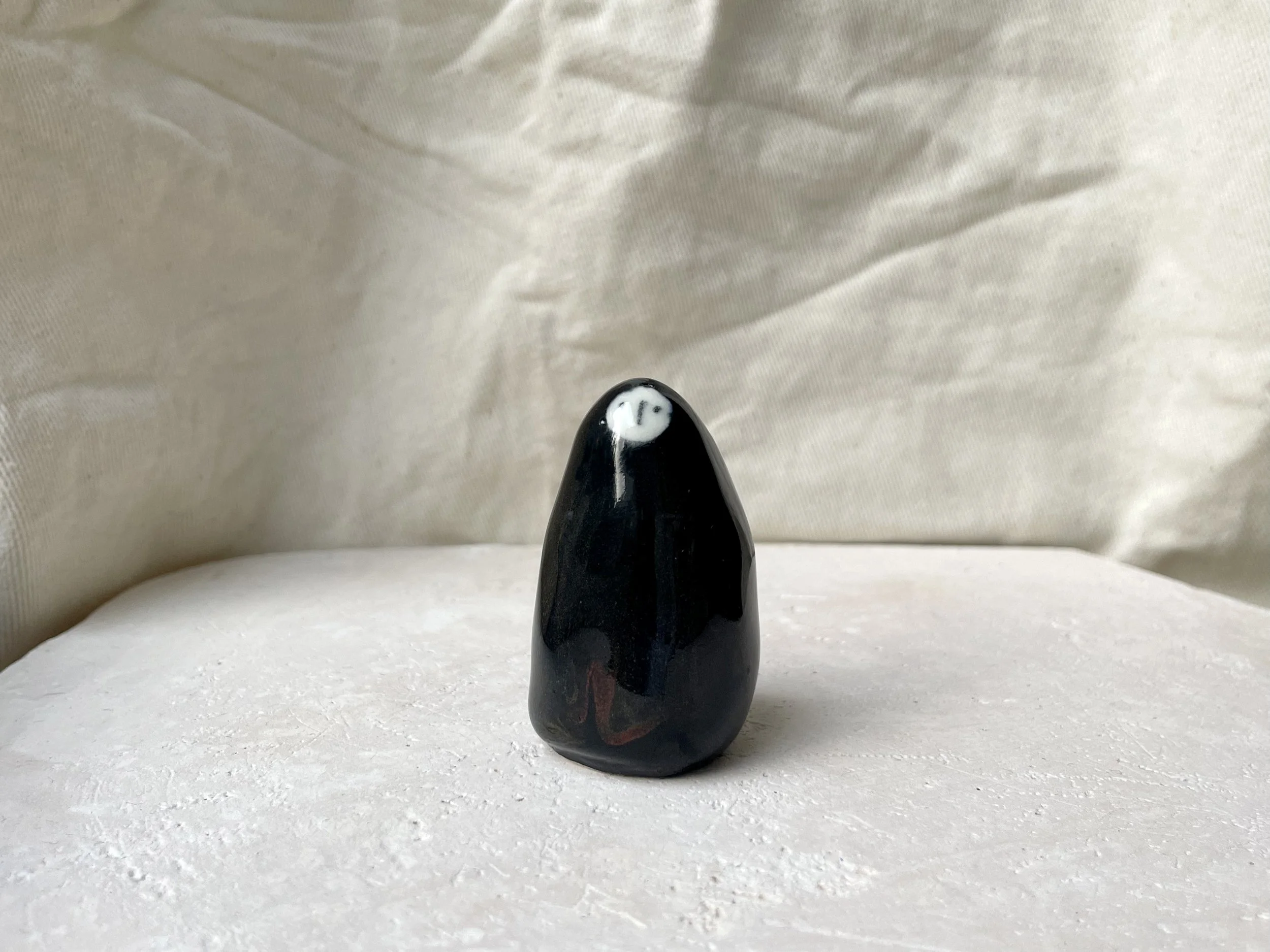 Black and red handmade figurative ceramic sculpture with glossy floating glaze