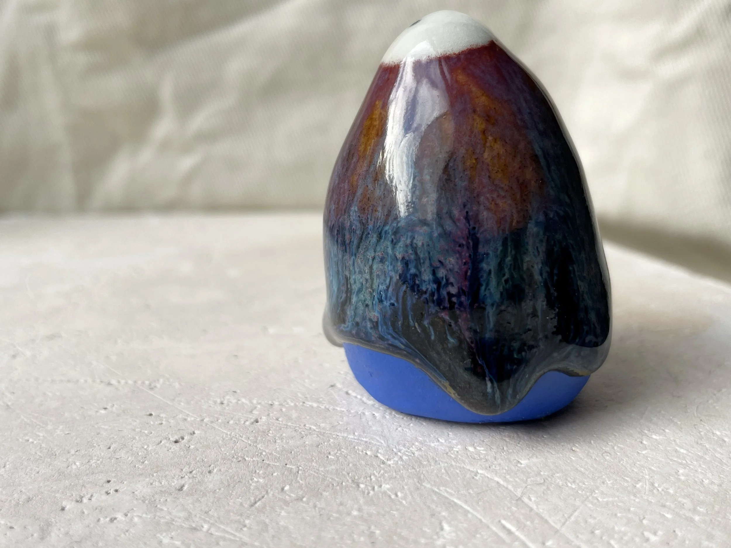 orange, purple, blue and black handmade figurative ceramic sculpture with glossy drippy floating glaze