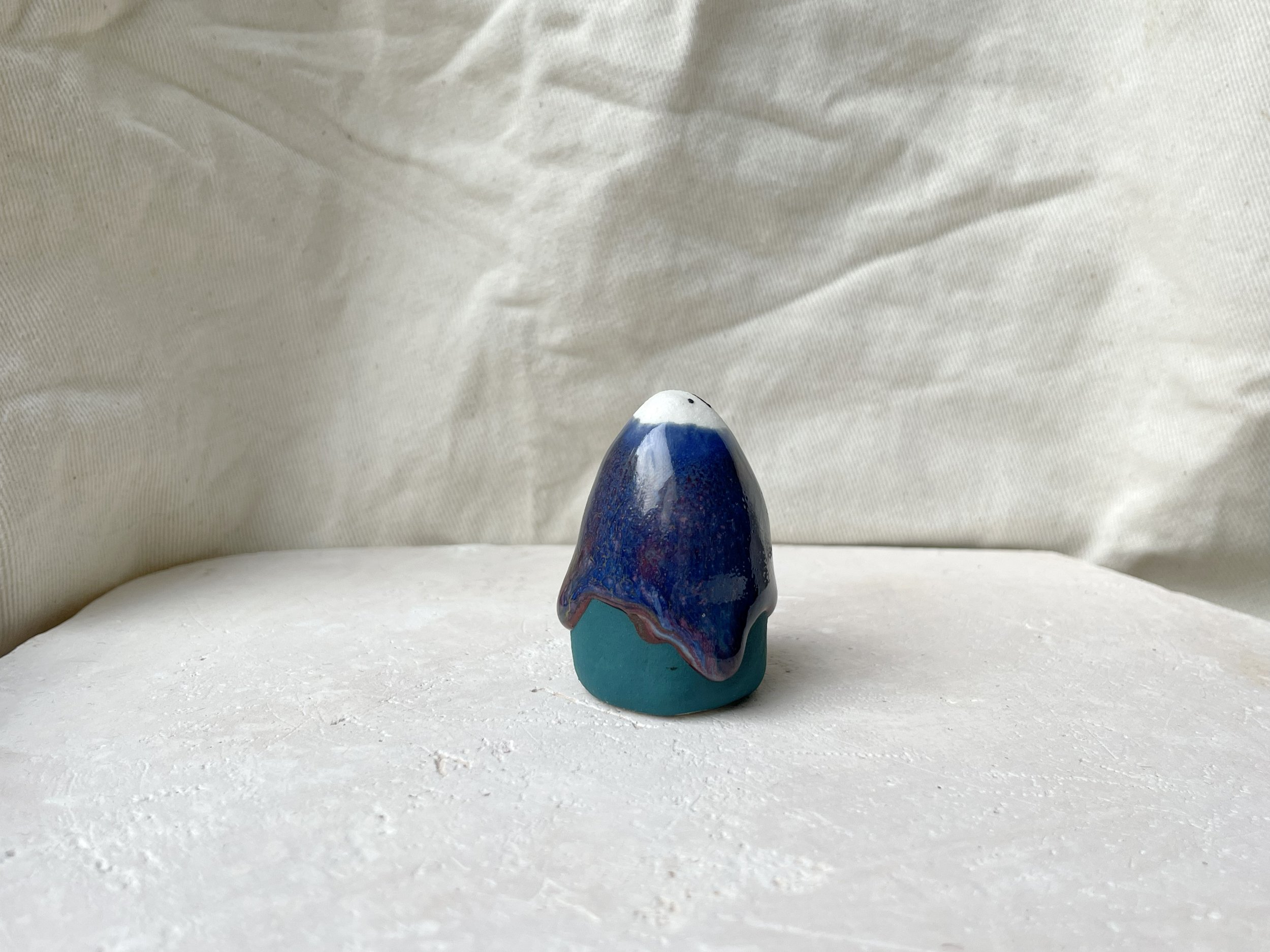 Blue, green and red handmade figurative ceramic sculpture with underglaze and drippy runny glaze