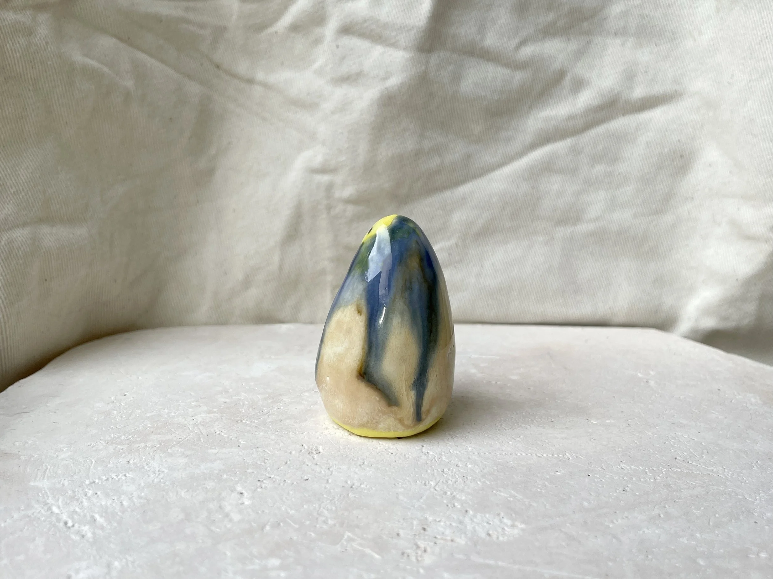 Yellow, blue and cream handmade figurative ceramic sculpture with glossy drippy glaze