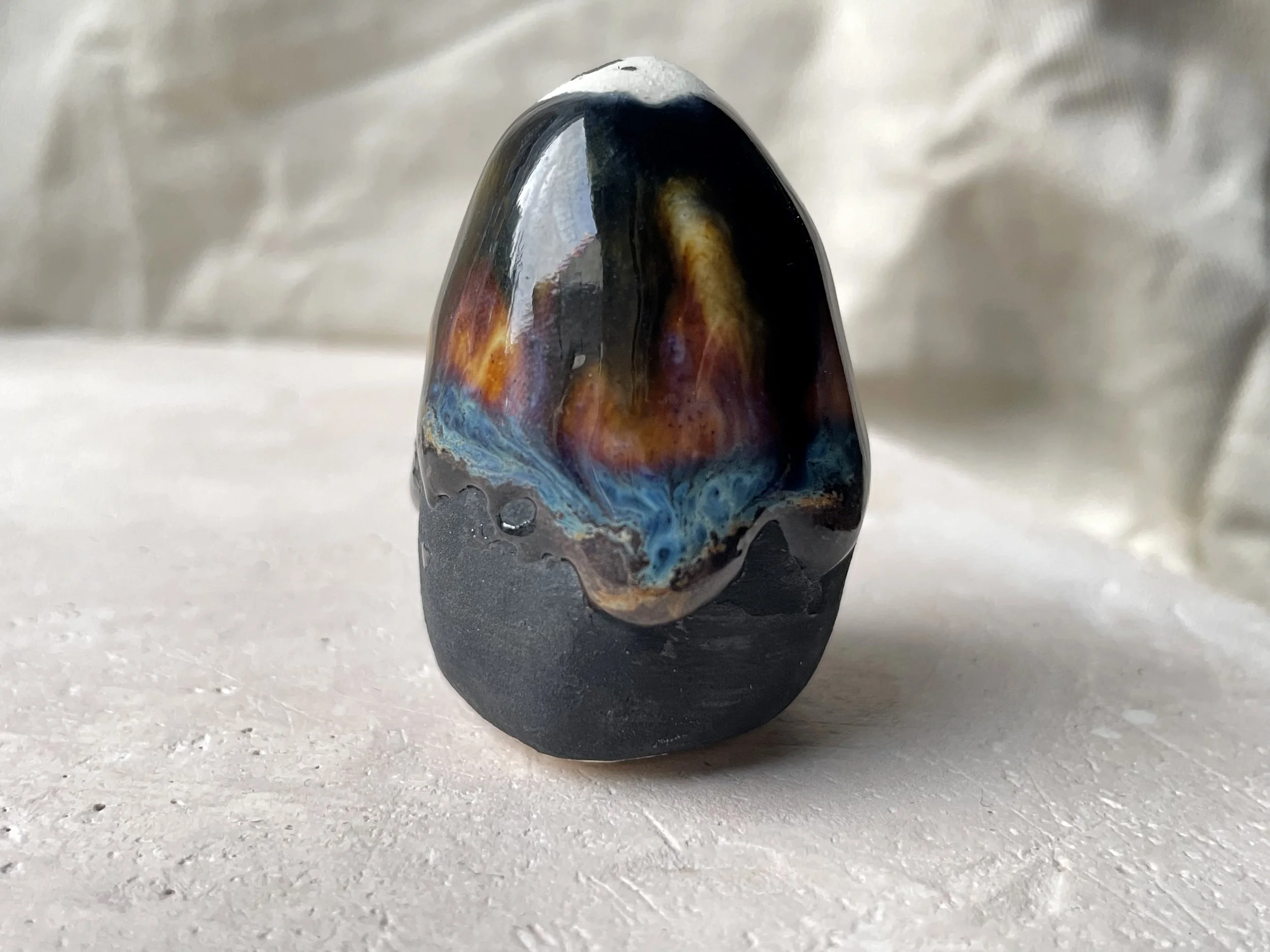 Black, orange and blue handmade figurative ceramic sculpture with underglaze and drippy float glaze