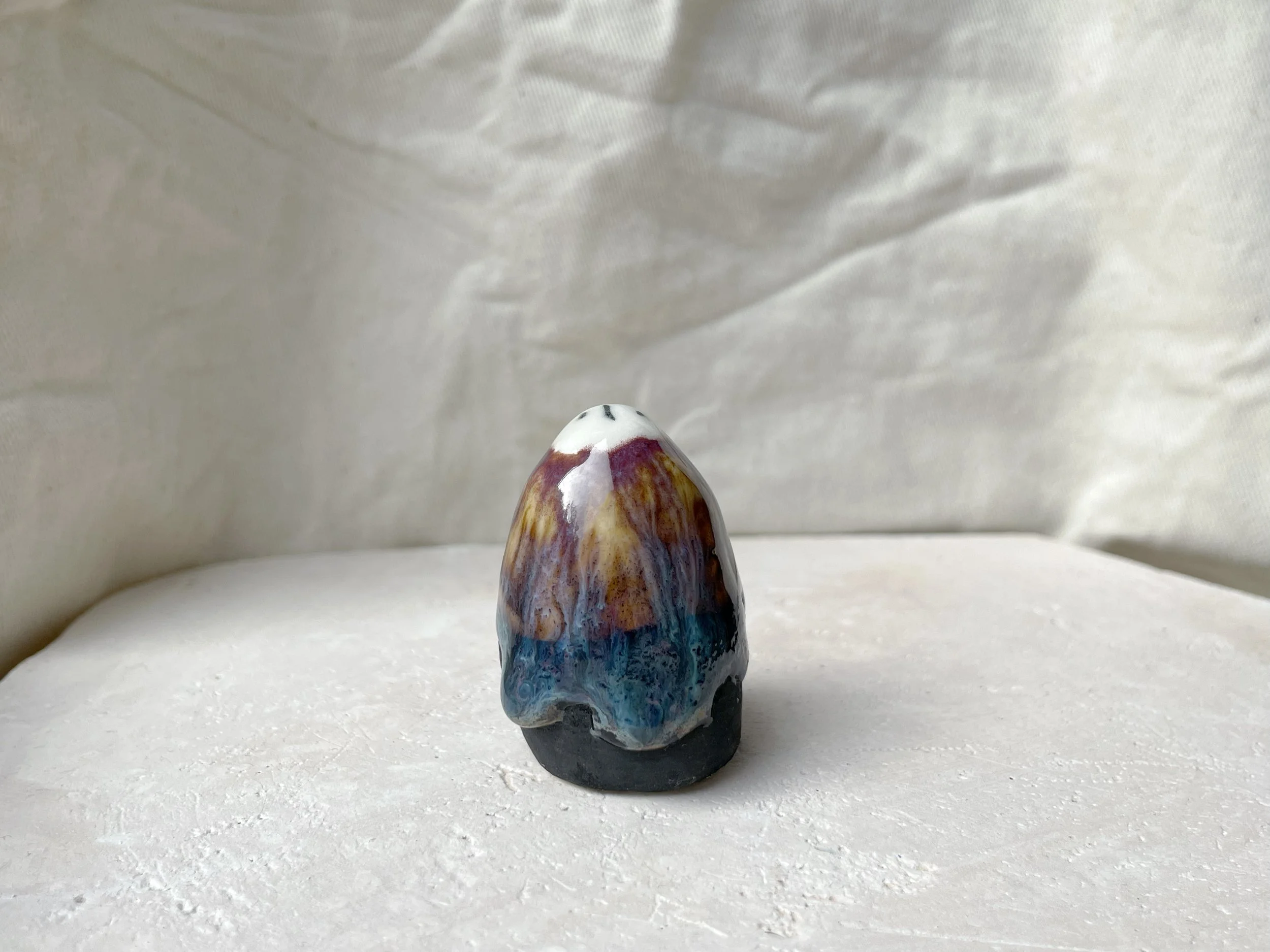 pink, blue, yellow, black handmade figurative ceramic sculpture with glossy floating glaze