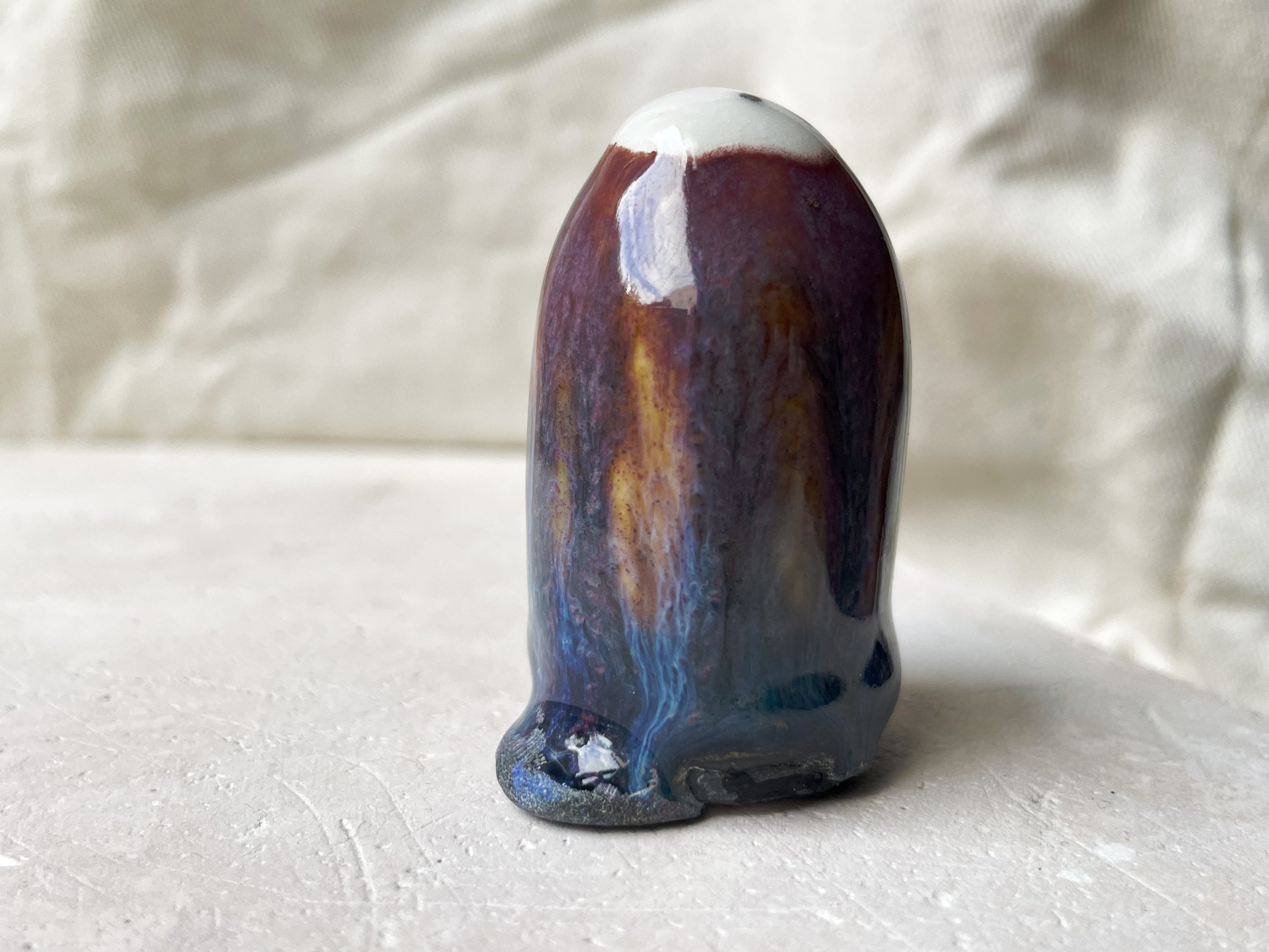Purple, orange, blue and black handmade figurative ceramic sculpture with underglaze and drippy float glaze
