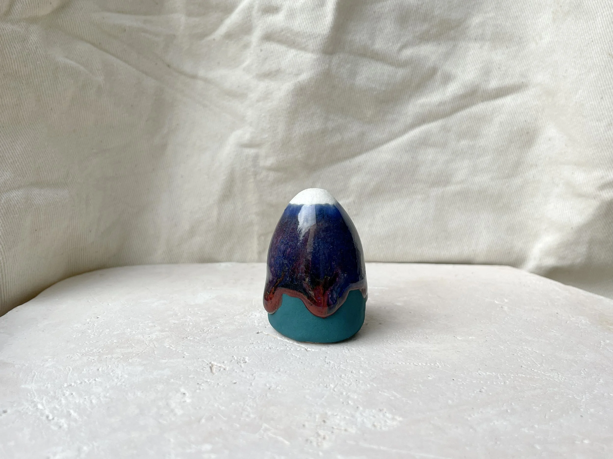 Blue, green and red handmade figurative ceramic sculpture with underglaze and drippy runny glaze