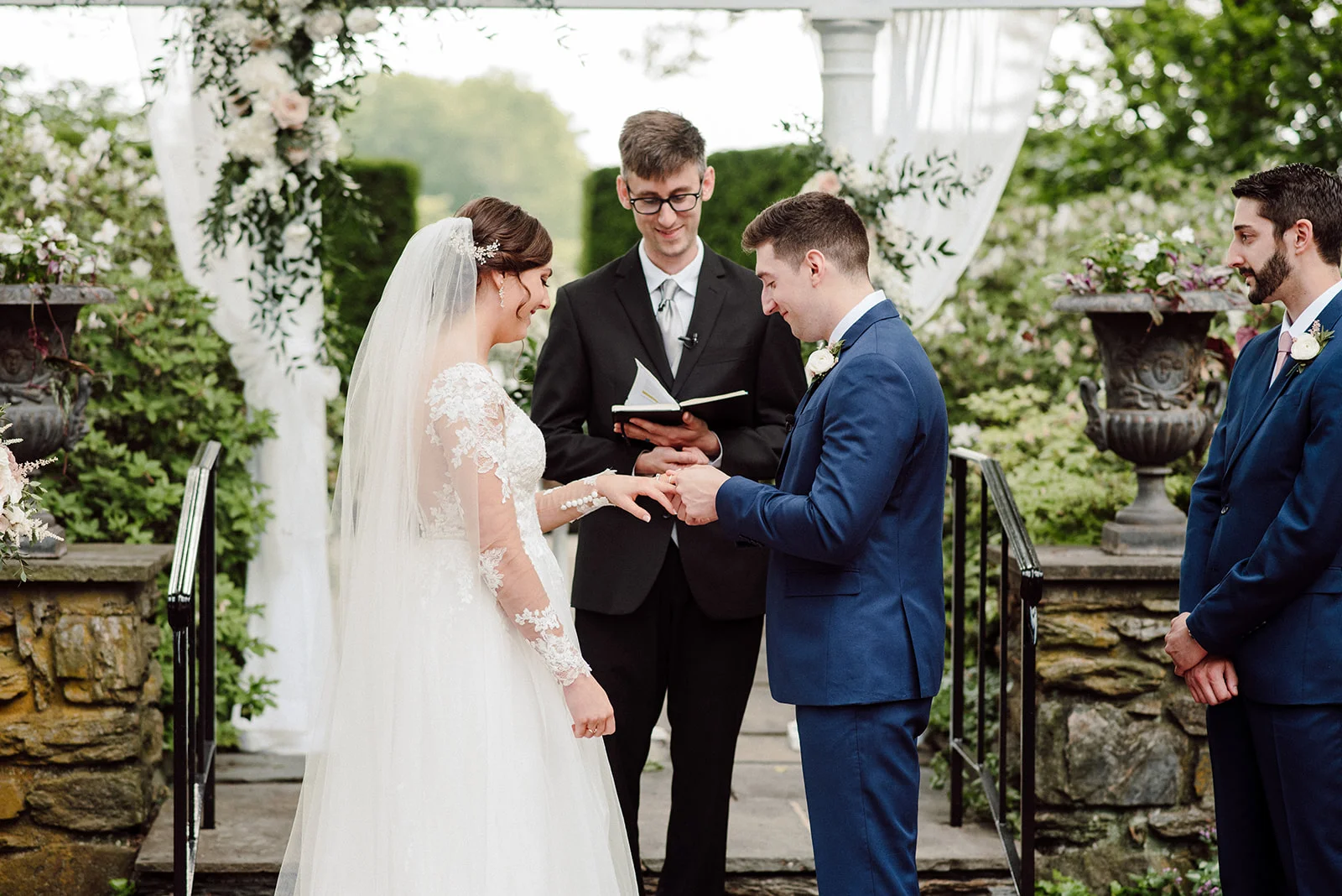 Groom places the wedding band on his bride.