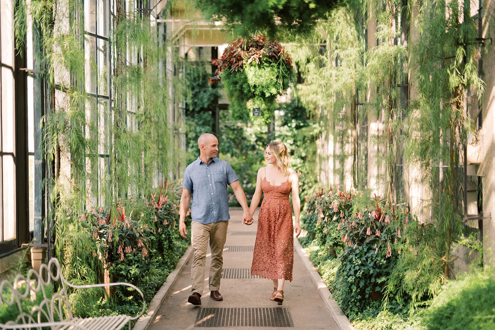 A couple walks through the conservatory at Longwood Gardens during their engagement session.