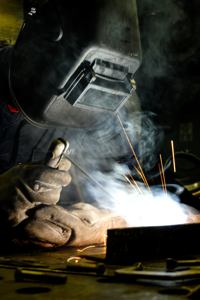 A machinist welds while at-sea aboard USS Boxer.