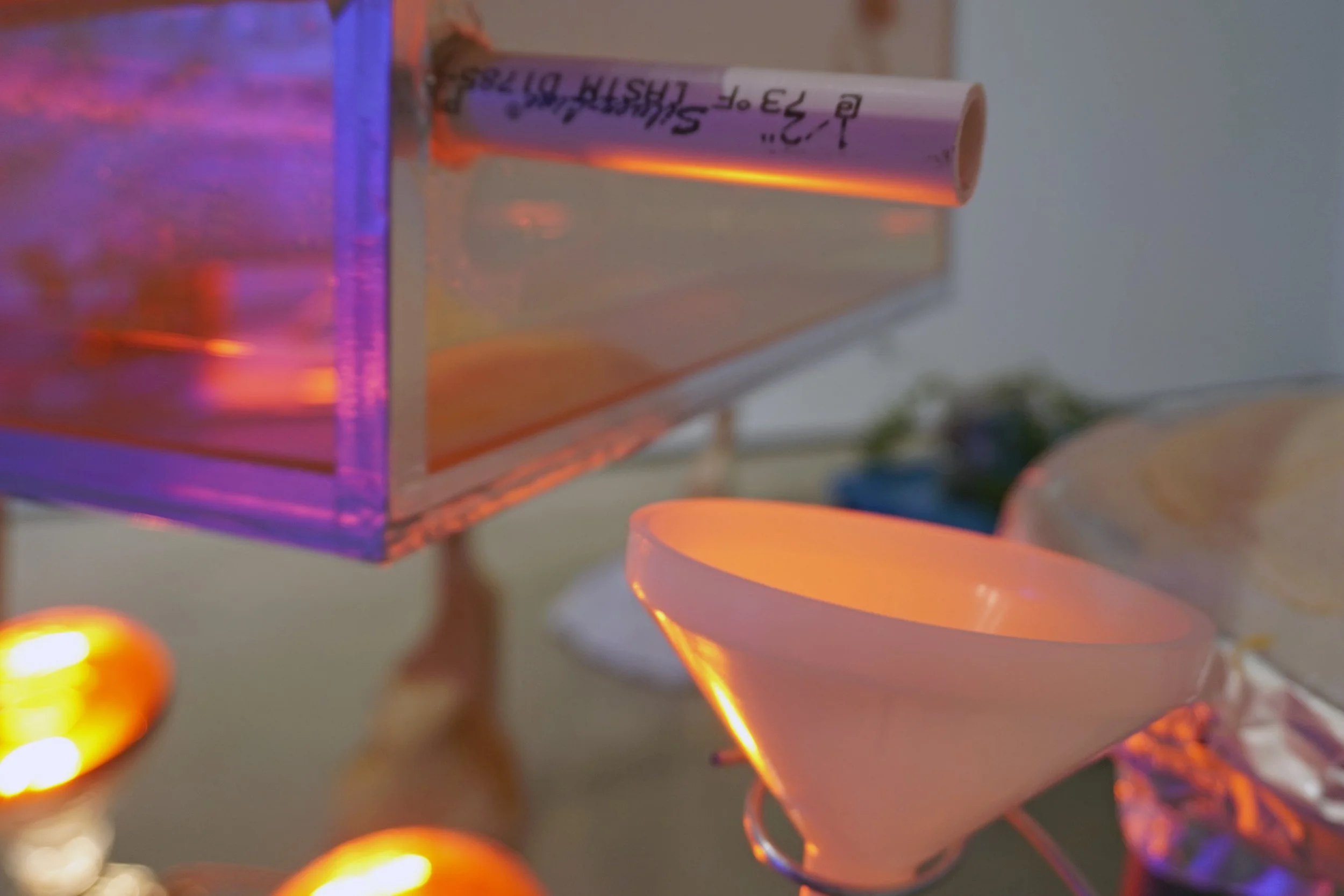 A PVC tube is suspended above a funnel, ready to collect and distribute the distilled substance.