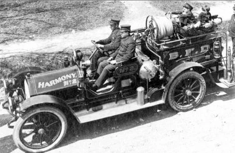 1916 Ford Model T Believed to be a Ford Model T Chassis, this was Harmony Hose & Engine's first motorized fire engine. It was also the first chemical engine in the Town of Boonton. Interesting notes about this particular photo: - Driver: William Kintscher - Passenger: Dawfy Righter - Children: Future Harmony Member Leo Lewis (with Cap) and Unknown
