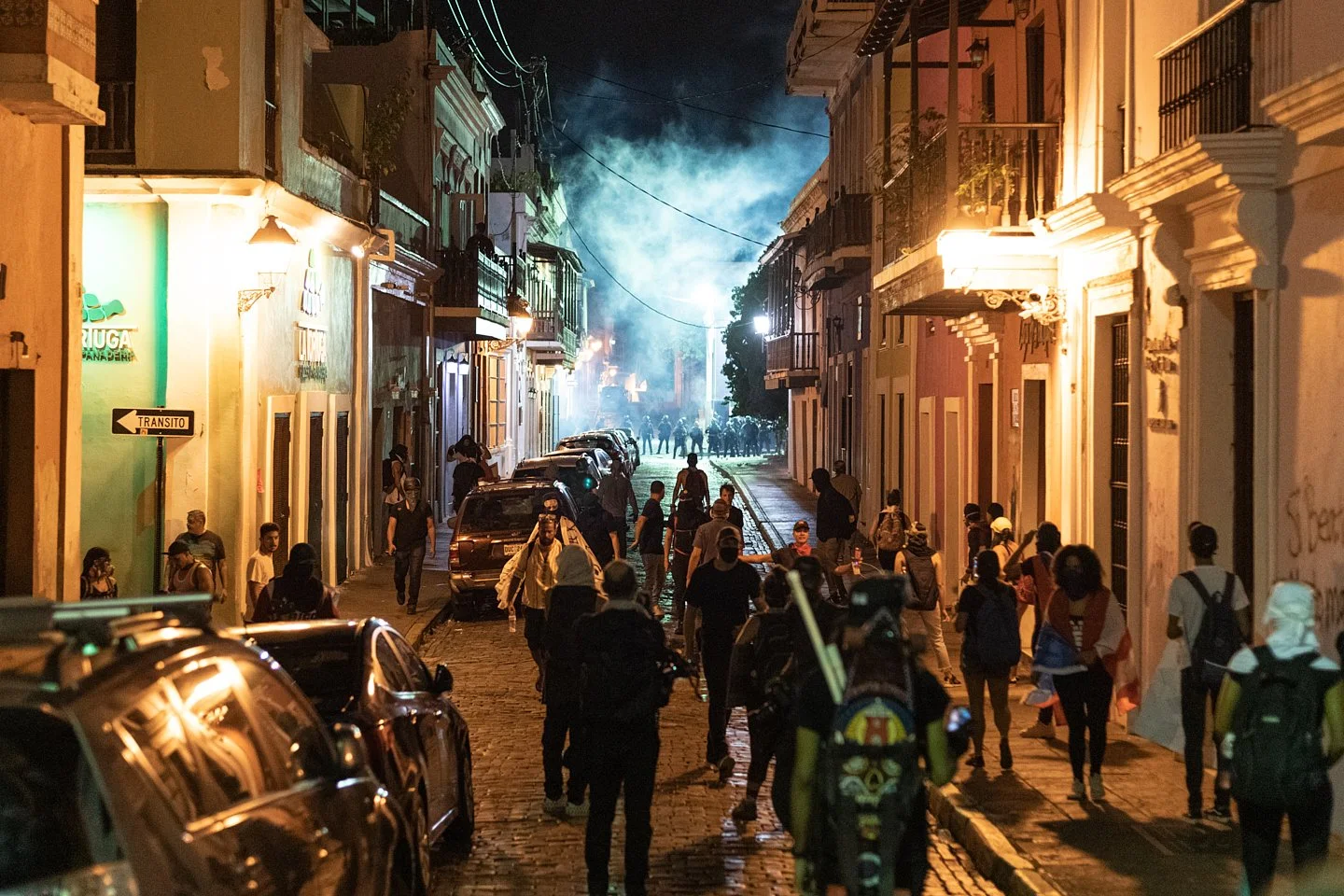  Demonstrators run from tear gas launched by police on Calle San Sebastian in Old San Juan after being forced away from the Governor’s mansion. Demonstrators clashed with police late into the night and early morning. San Juan, Puerto Rico, July 18th,
