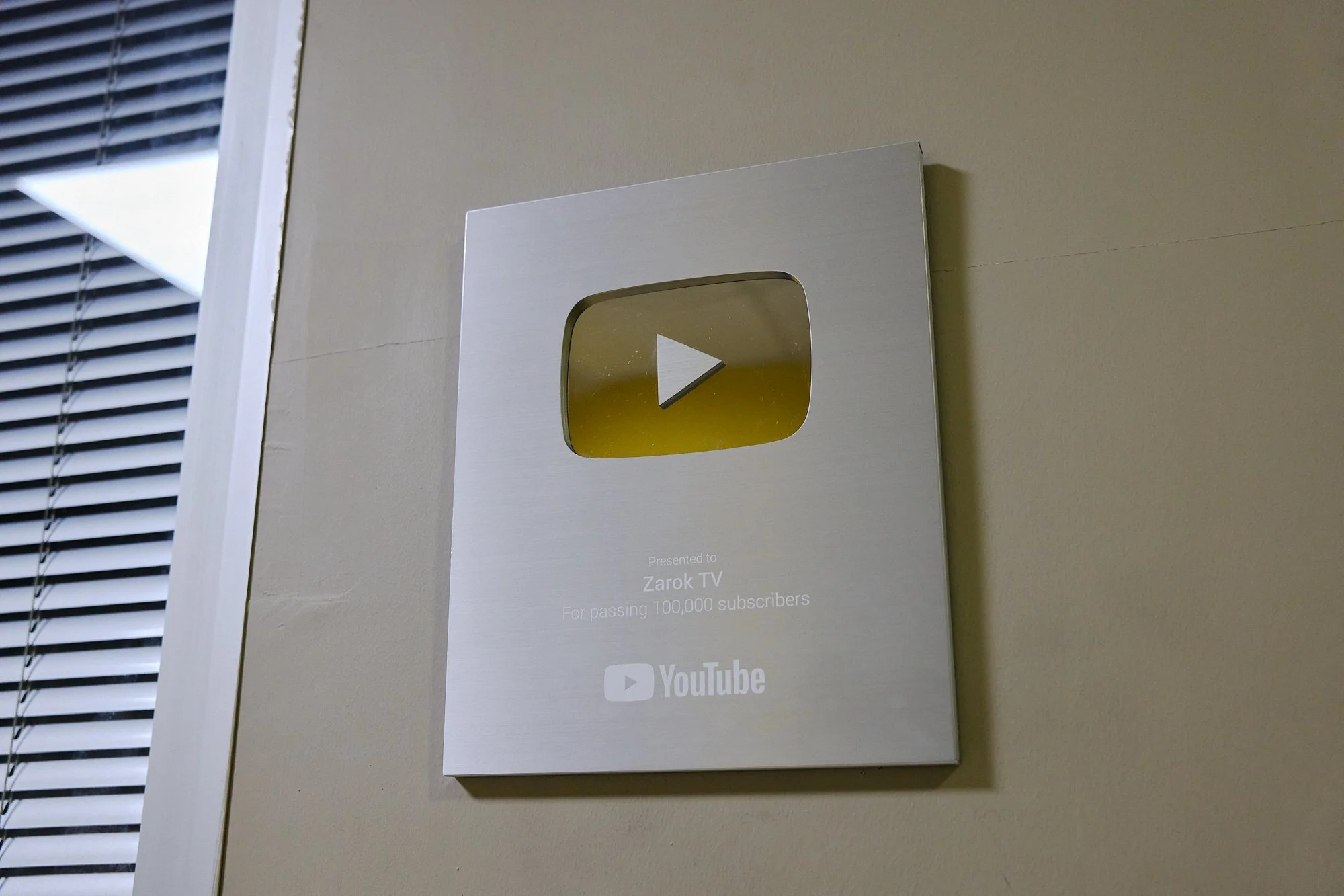  A YouTube channel plaque adorns the walls of the Zarok TV office, showing they have surpassed 100,000 subscribers on the social media platform. As of February 2026, the channel has more than 218,000 subscribers. 