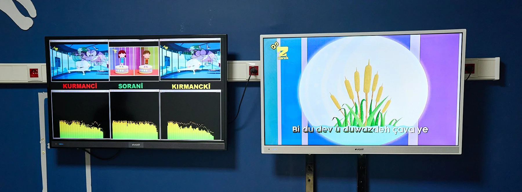  Screens depict a live simultaneous broadcast of cartoon programs in three Kurdish dialects. 