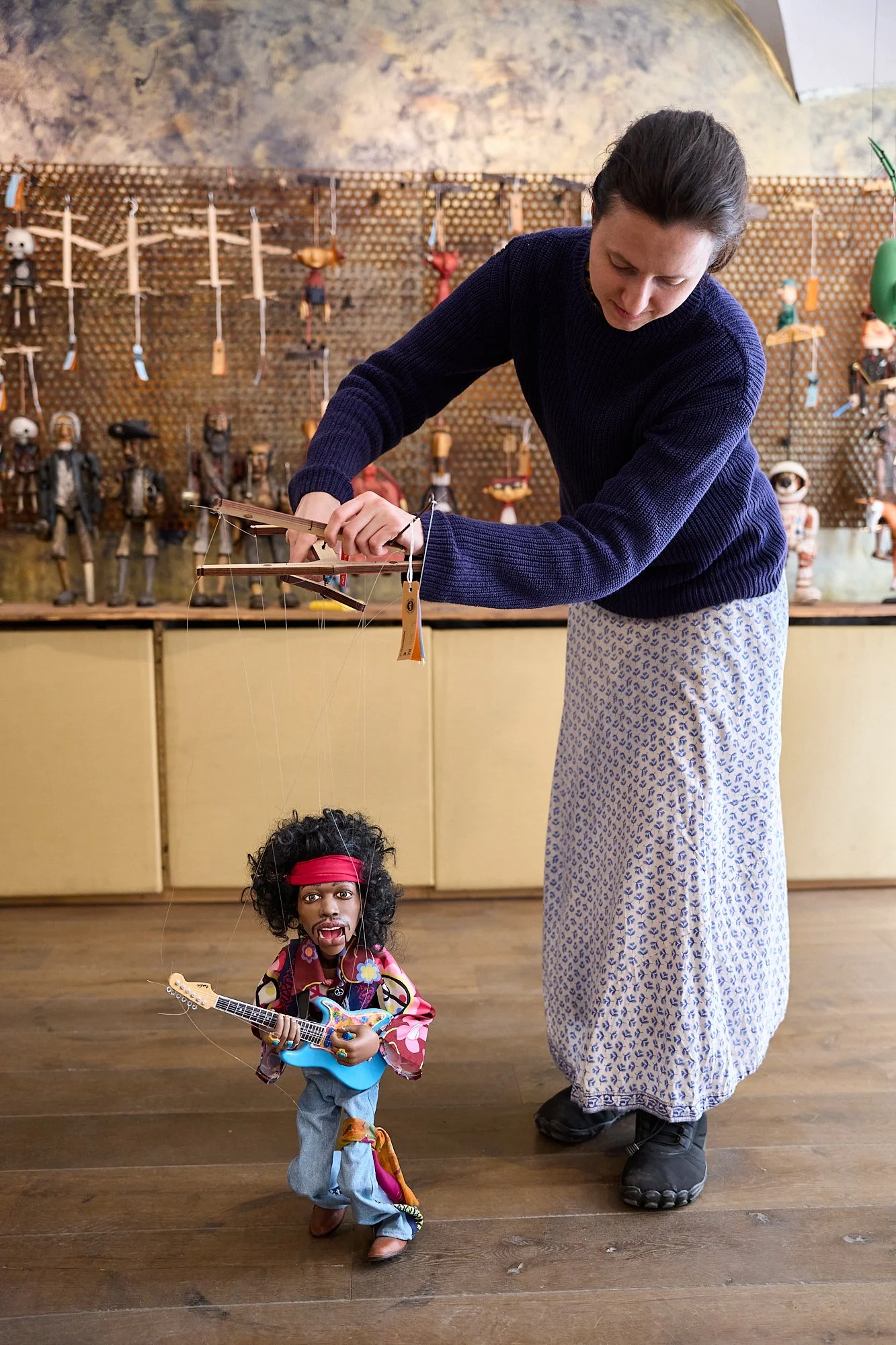  A store worker at Czech Marionettes in Prague, Czech Republic  plays with a puppet version of Jimmy Hendrix at the front of the store.  