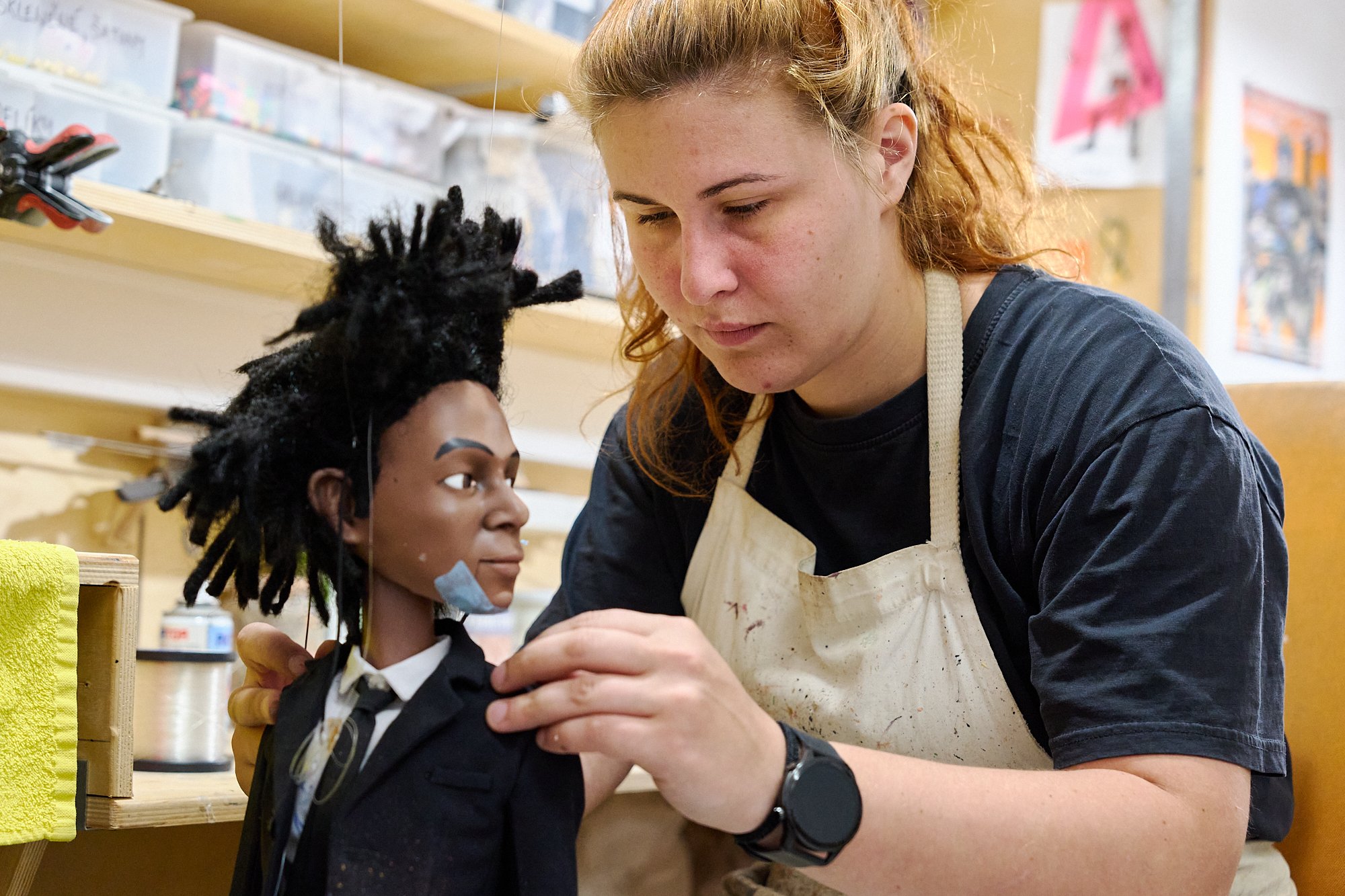  A puppetmaker in the back workshop of the Czech Marionette store puts the finishing touches on a custom puppet.  