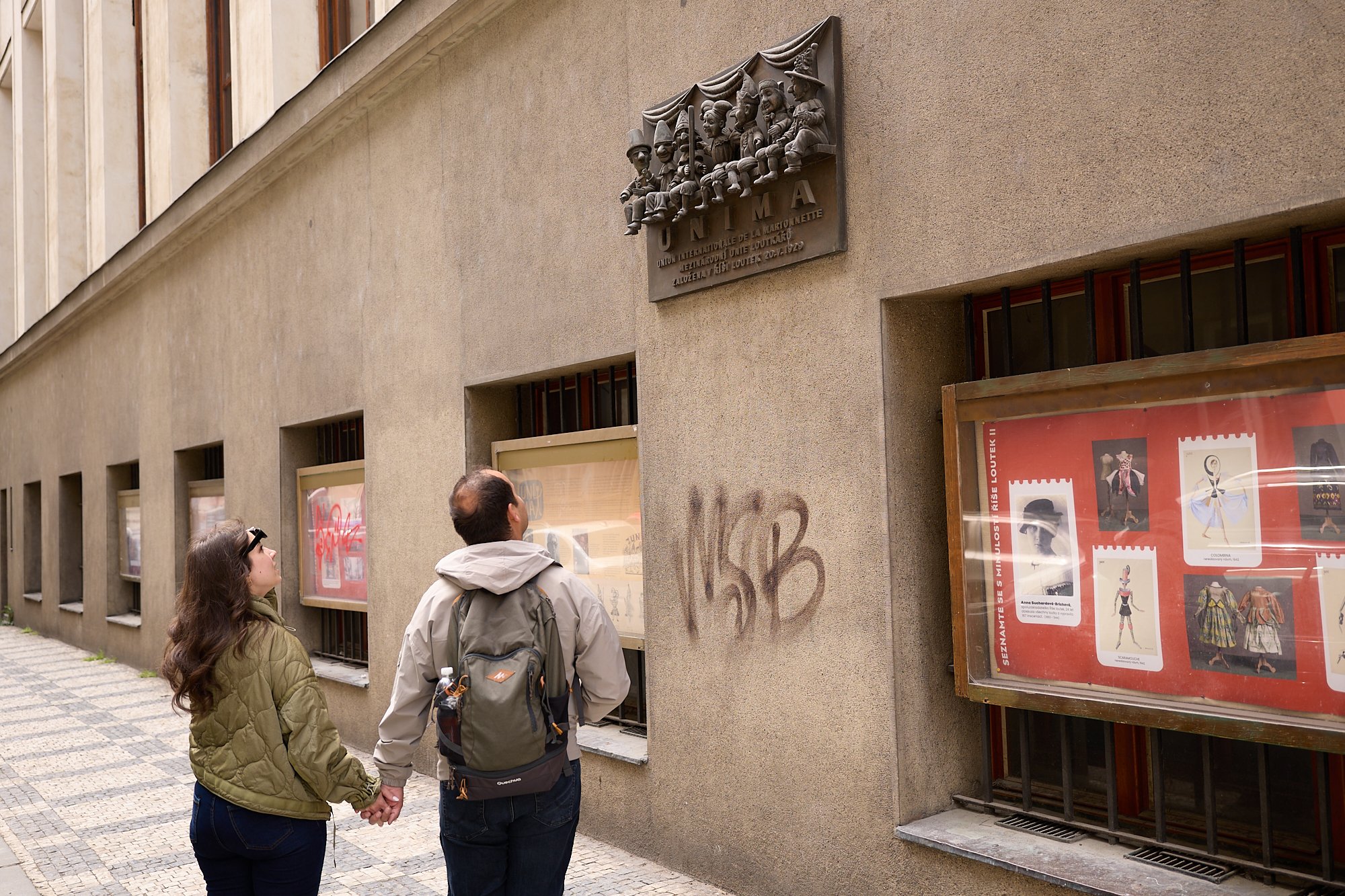  Travellers gaze at a plaque that hangs outside of the National Marionette Theatre in Prague. A UNESCO recognized artform in Czechia and Slovakia, marionette theatre is deeply engrained in Czech culture and history.  