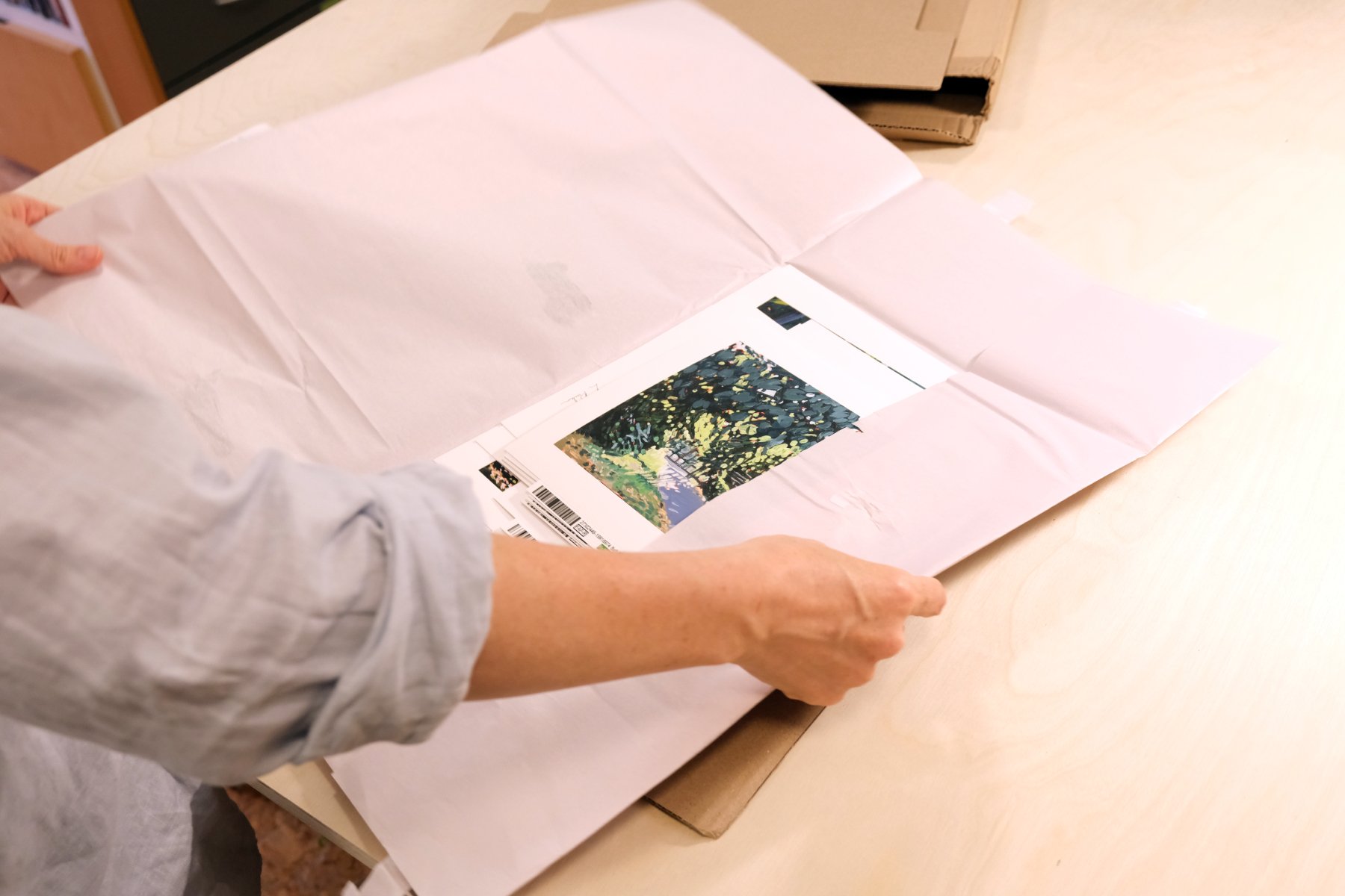 Hands unwrapping the packaging a Leslie Parker fine art print arrives in