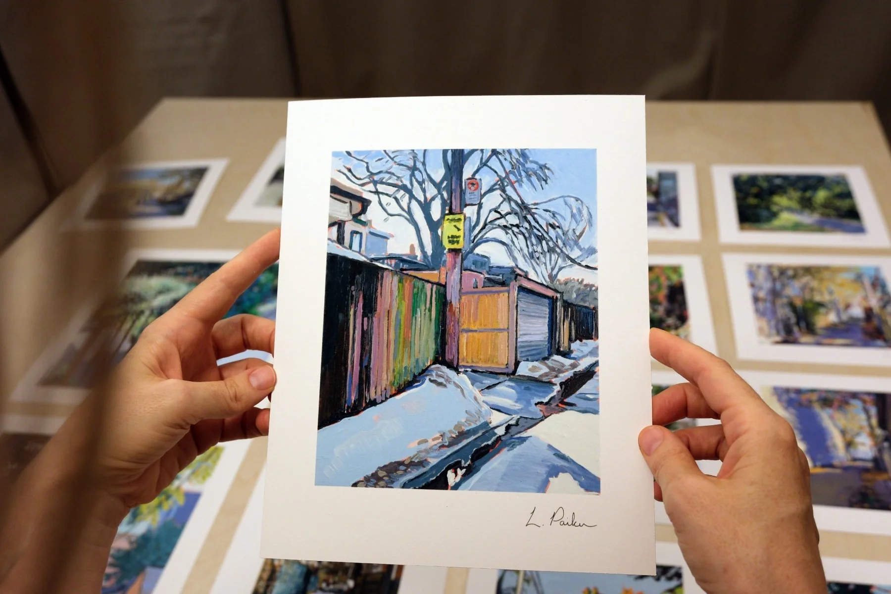 Leslie Parker holding a fine art print of a Toronto laneway in thaw