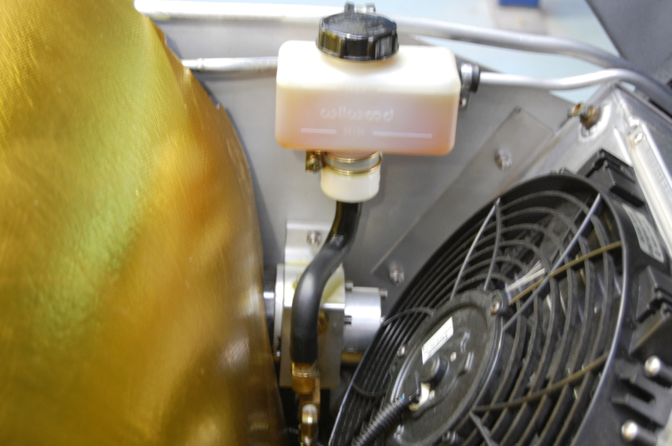 Detail of lift kit pump and reservoir installed in front radiator compartment on a Superlite SL-C.