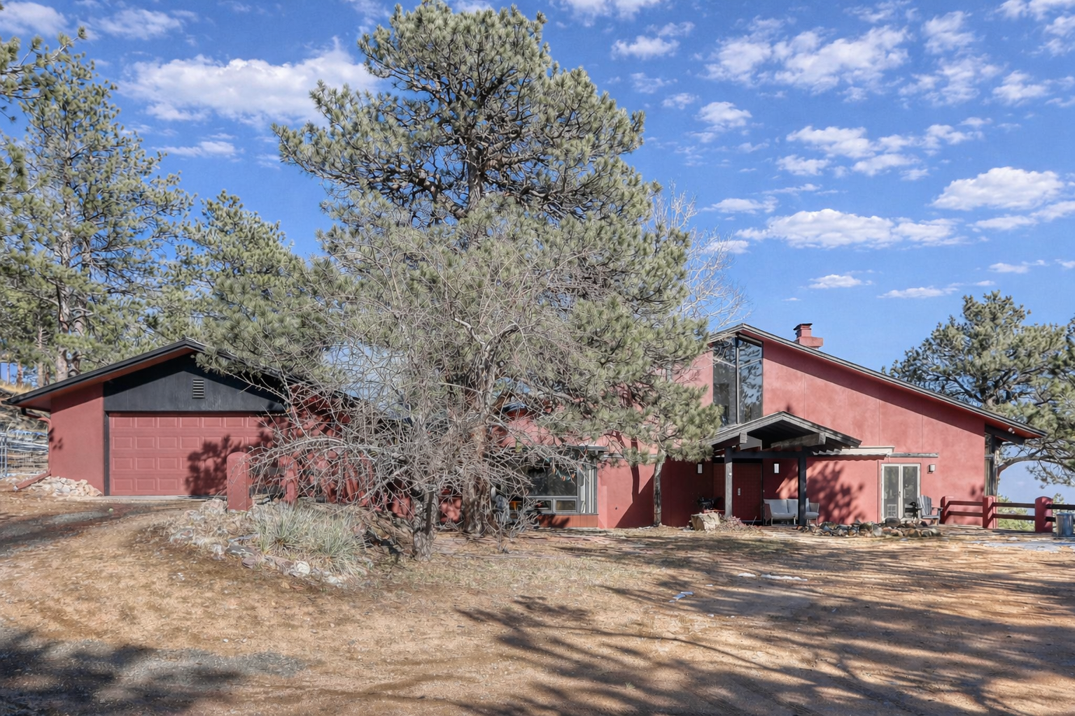 Modern red house in a wooded setting.png