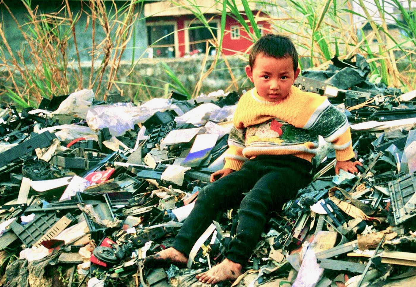 Boy in Guiyu, China, atop a pile of electronic waste. Creative Commons, Basil Action Network, 2017.