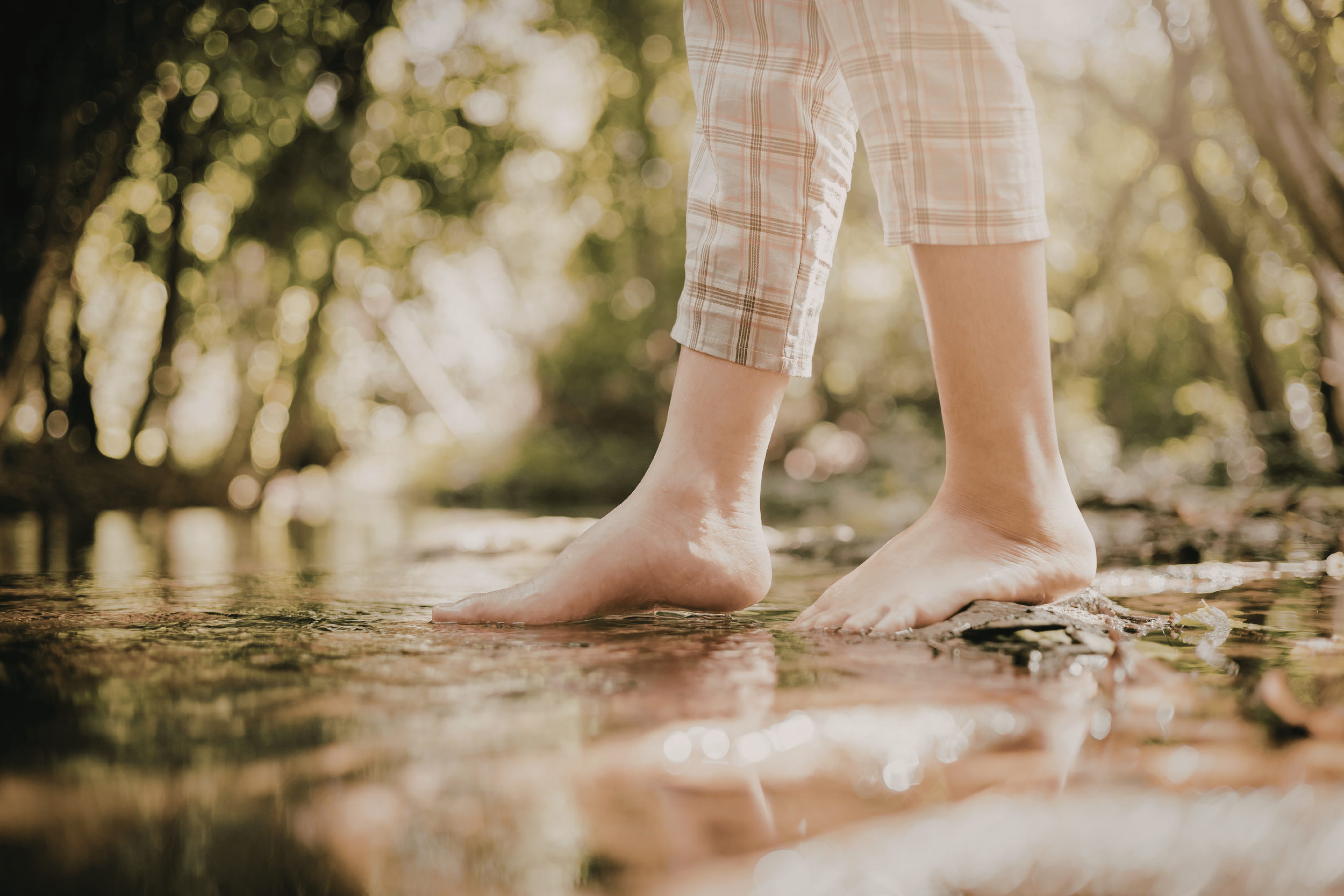 Person walking barefoot on green grass in nature as a mindful Spring Equinox ecotherapy practice for grounding and well-being