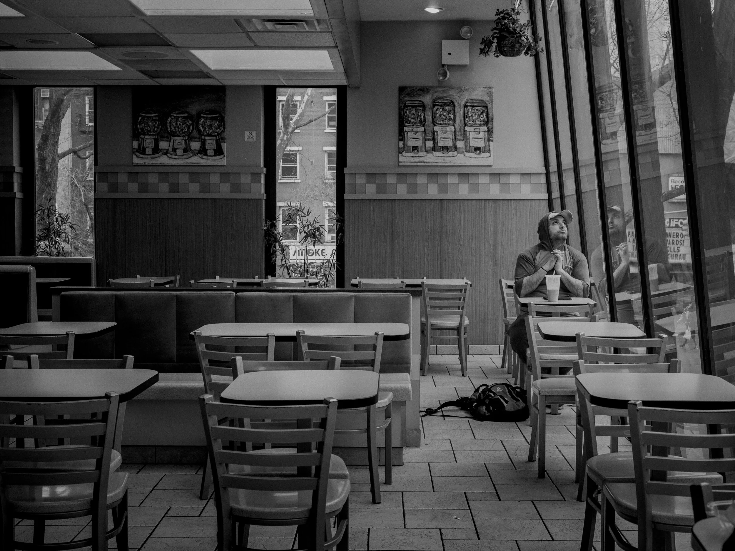  After watching two men in protective gear on the street, a man prayed at an empty fast food restaurant in downtown New York. 
