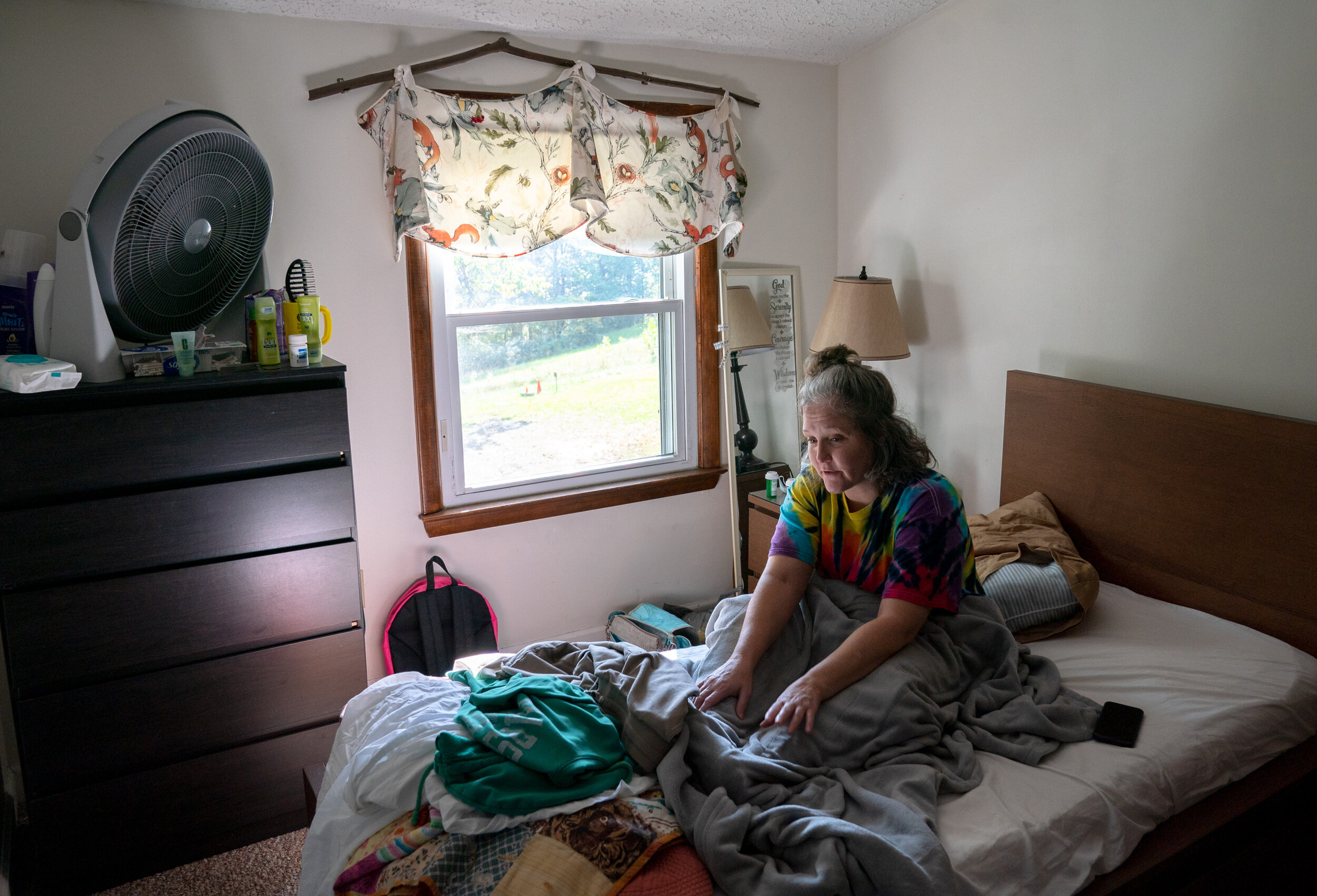 Resident Charity Whitcraft, 40, originally from Albany, Ohio, sits up from a nap in her bedroom on Oct. 5, 2021 at Serenity Grove in Athens, Ohio. “I’m not supposed to be up here laying in bed all day, but sometimes I can’t help it,” Whitcraft said.